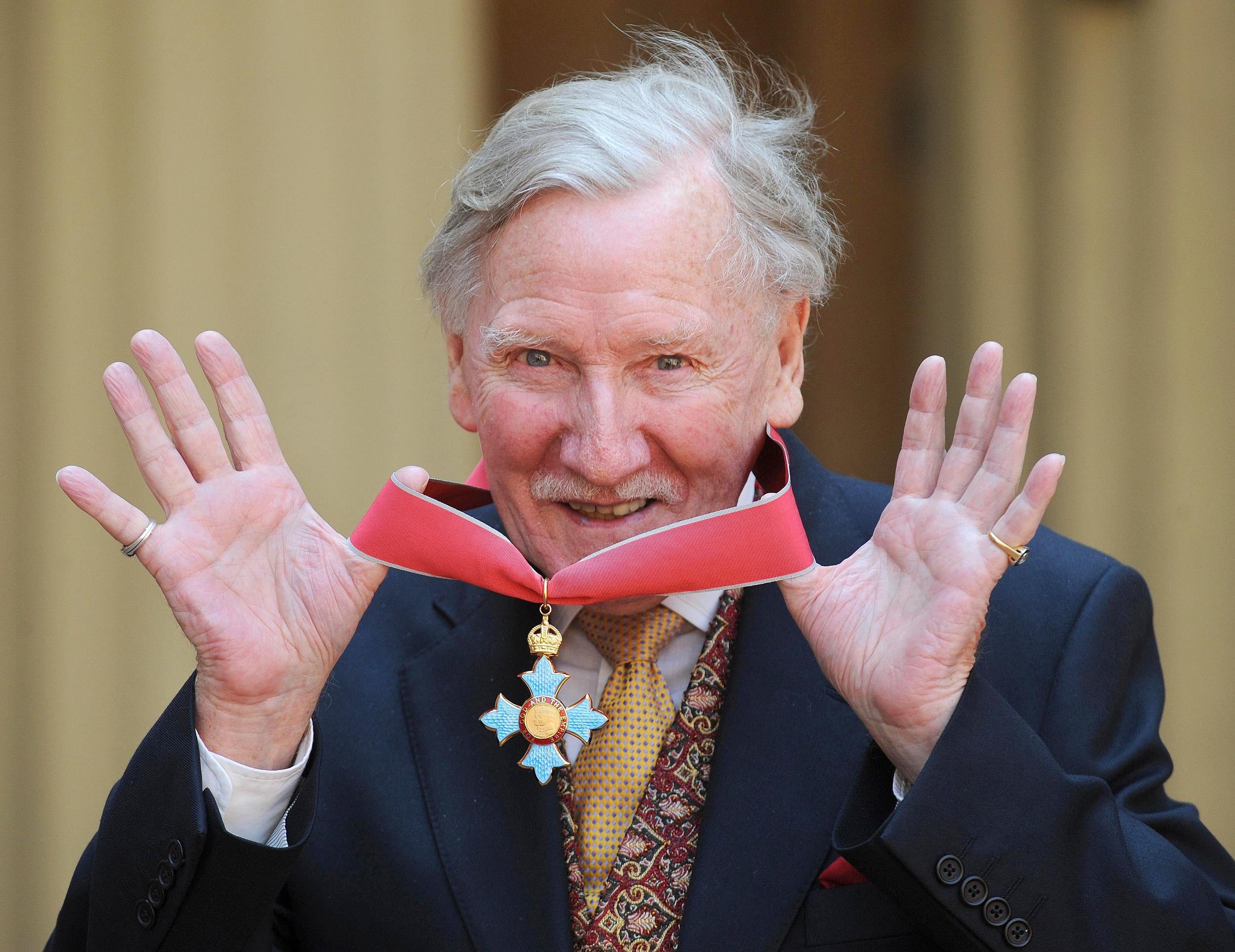 With his CBE, which was given to him by the Queen in 2008