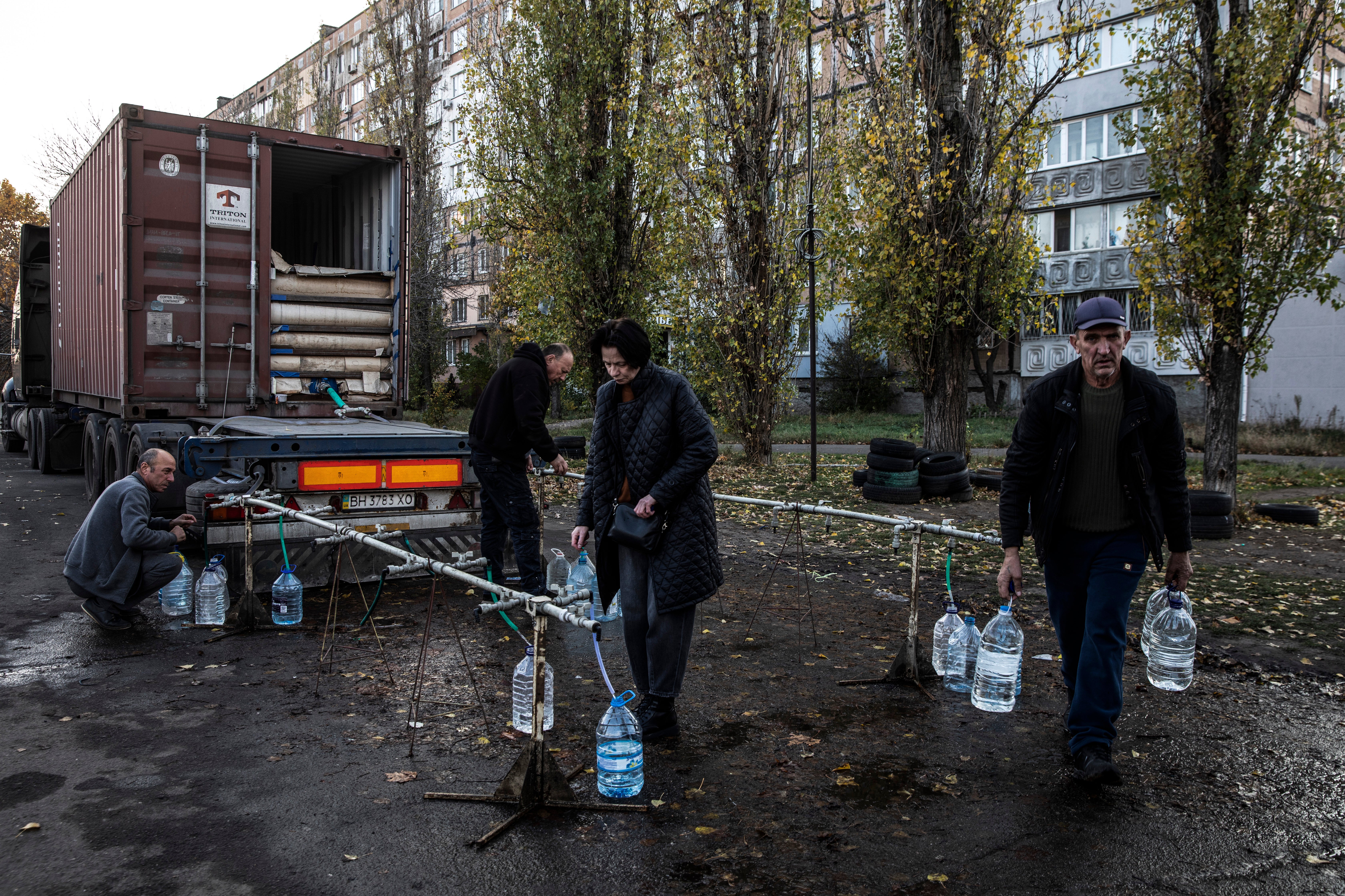 Irina Nasietkina, 55, an unemployed engineer, collects fresh water for her son at a delivery truck