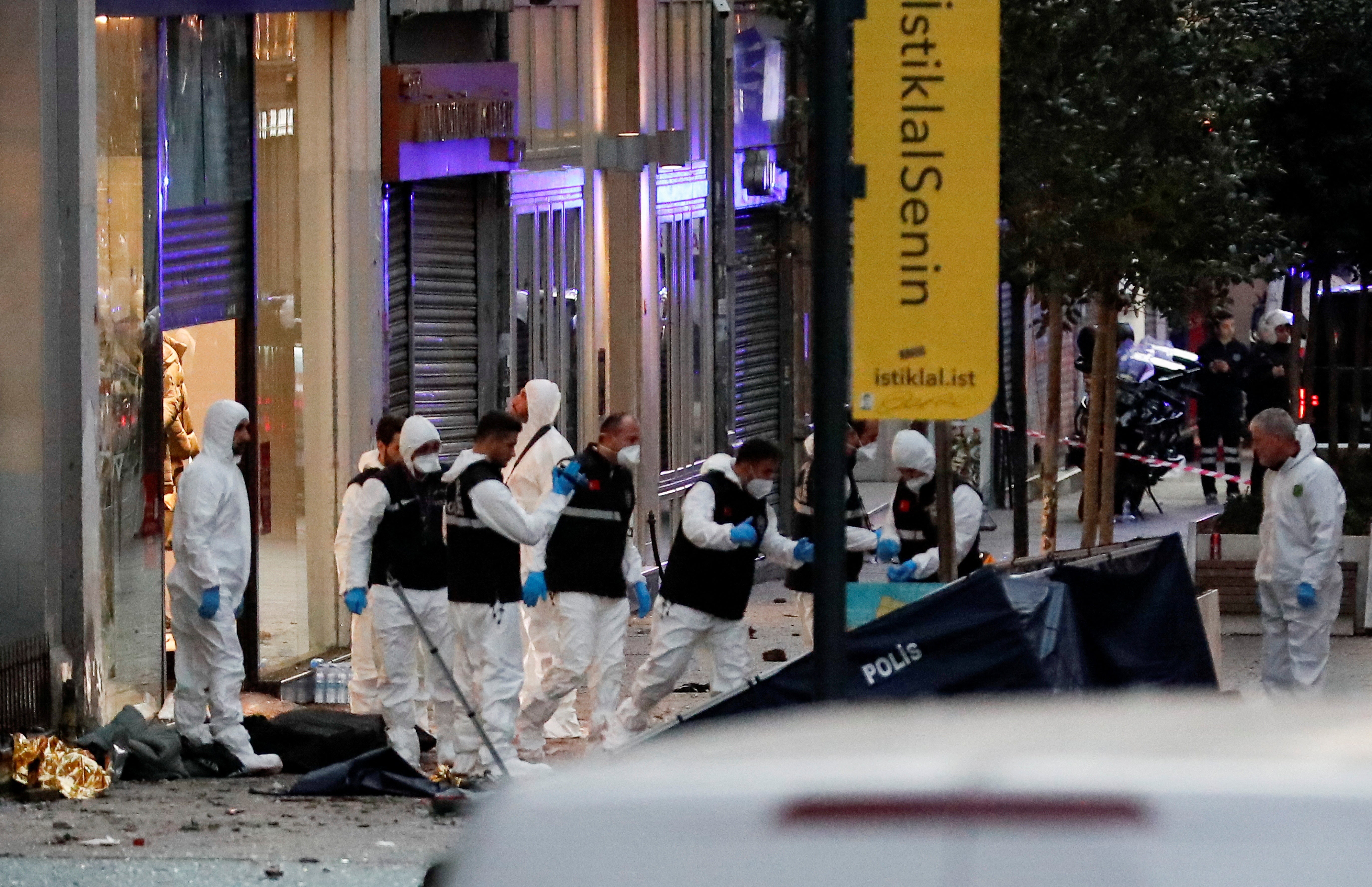 Police work near the bodies of unidentified people after the explosion