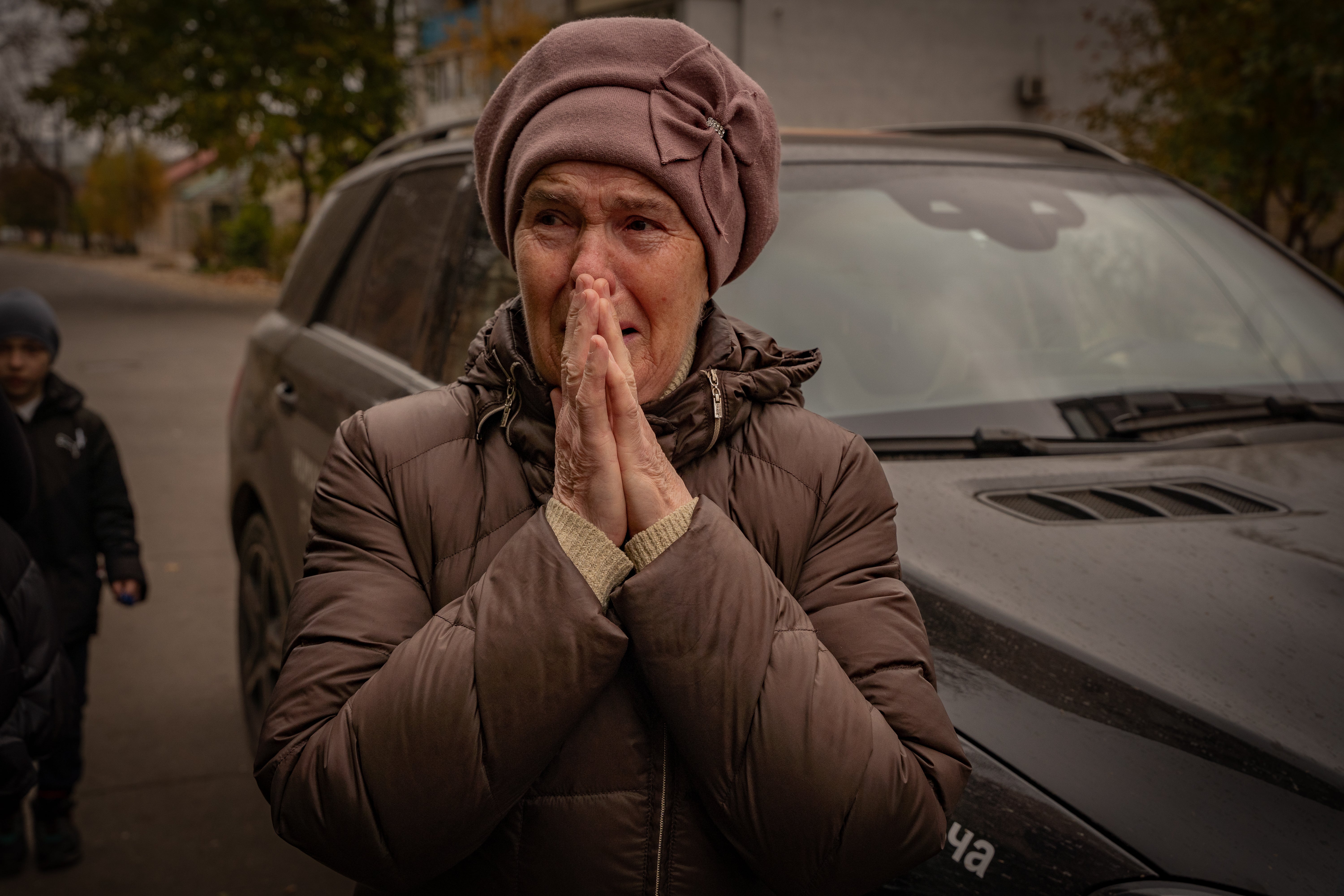 Ludmila, 76, weeps as she gets a bag of food aid after losing her son and living without electricity and water