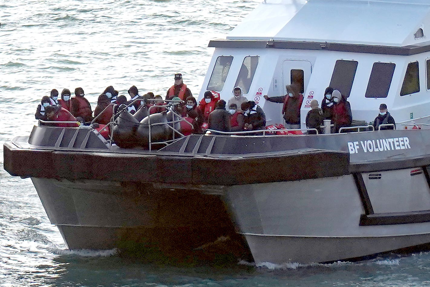 A group of people thought to be migrants are brought into Dover