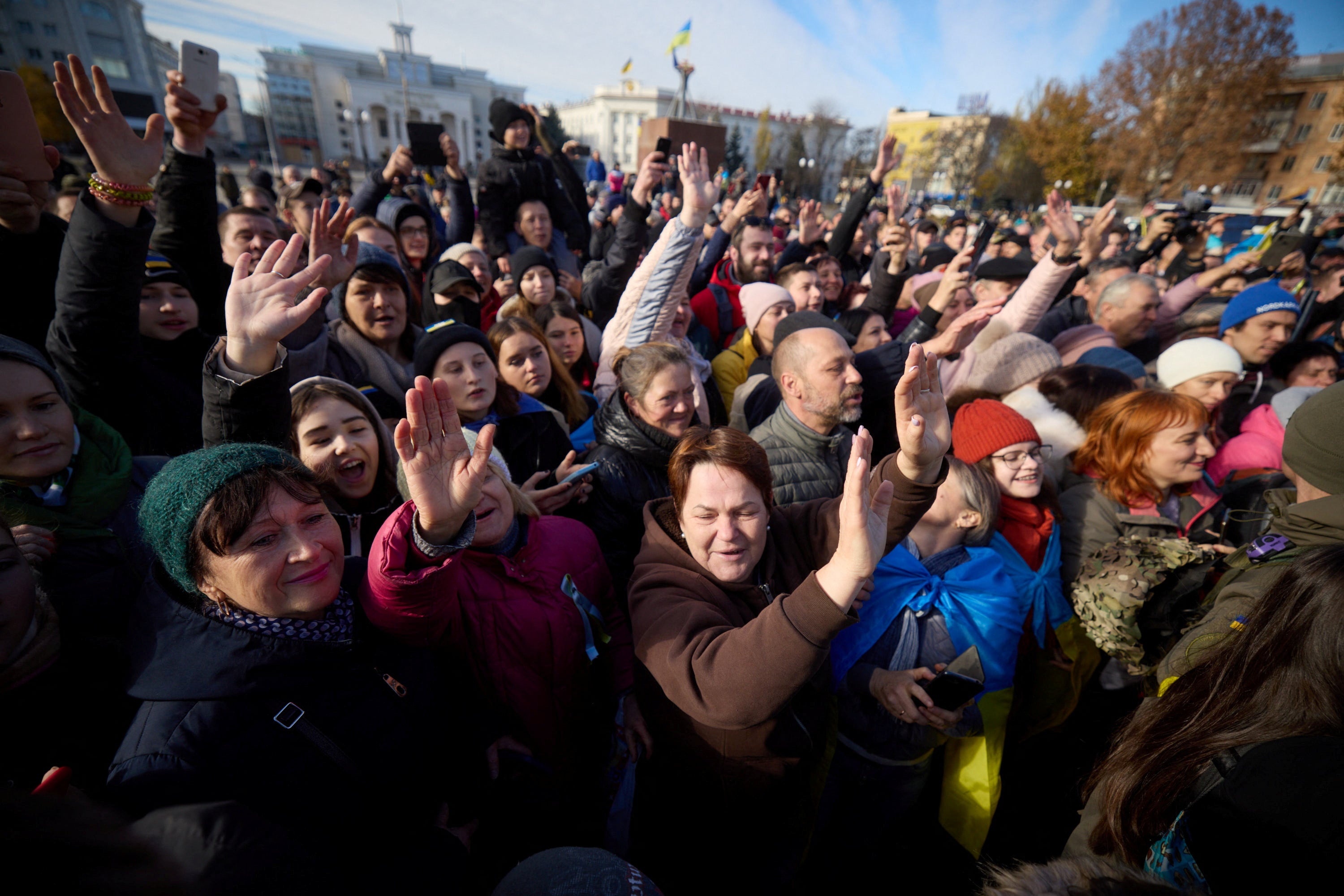 Local residents gesture as Ukraine’s President Volodymyr Zelensky visit Kherson