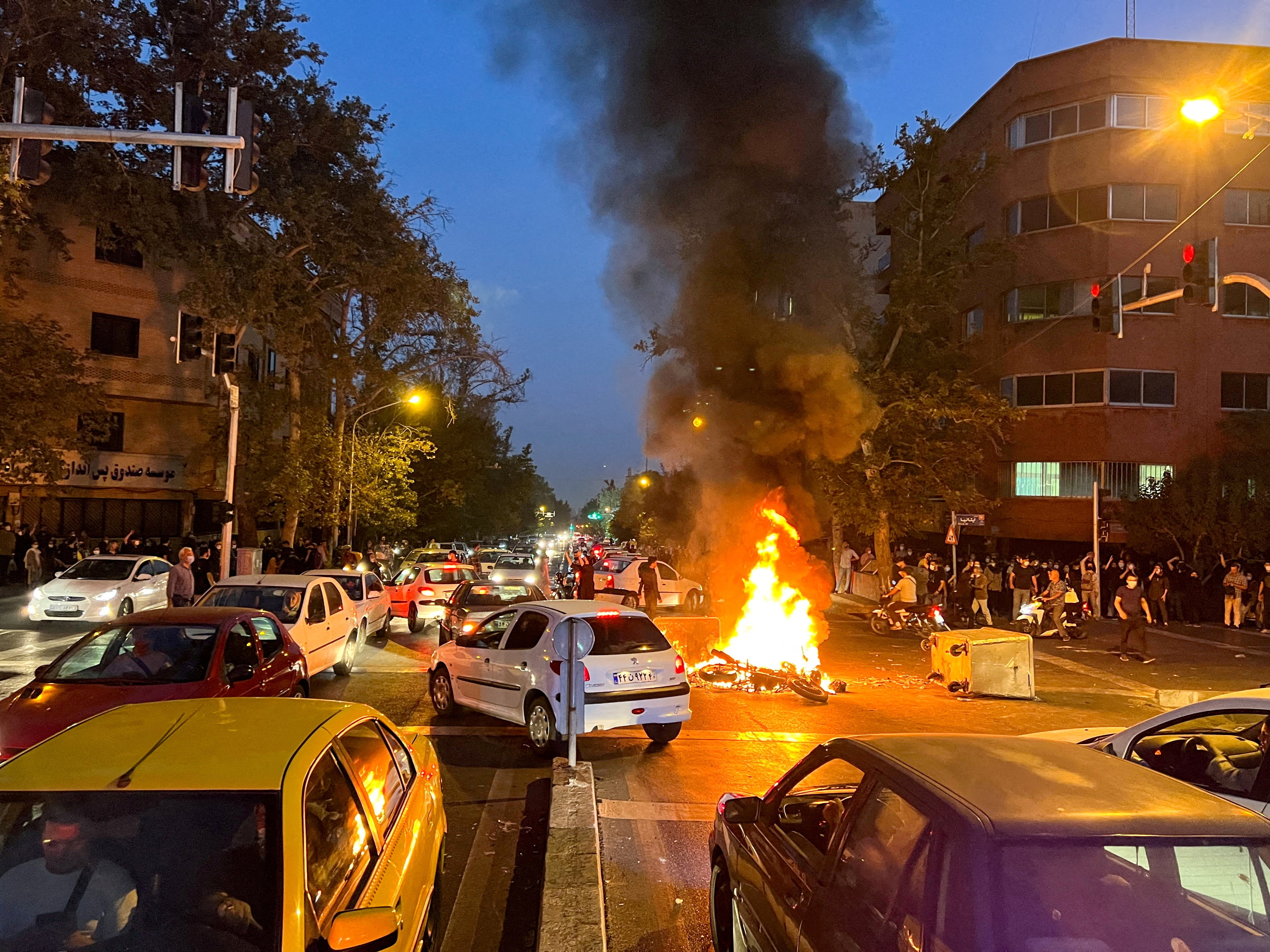 A police motorcycle burns during a protest over the death of Mahsa Amini in central Tehran