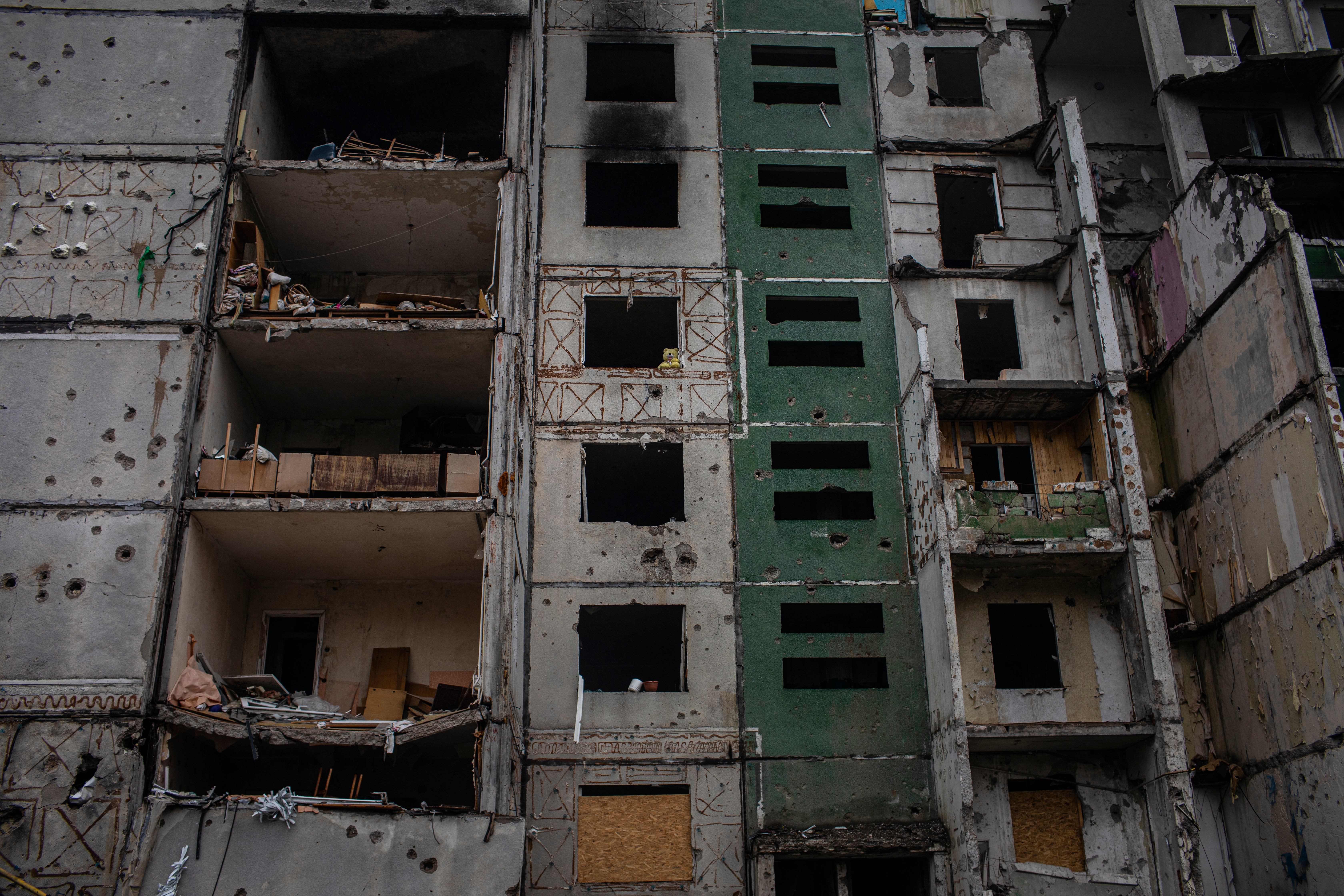 A teddy bear is seen propped up in a window of a destroyed apartment in Chernihiv city centre