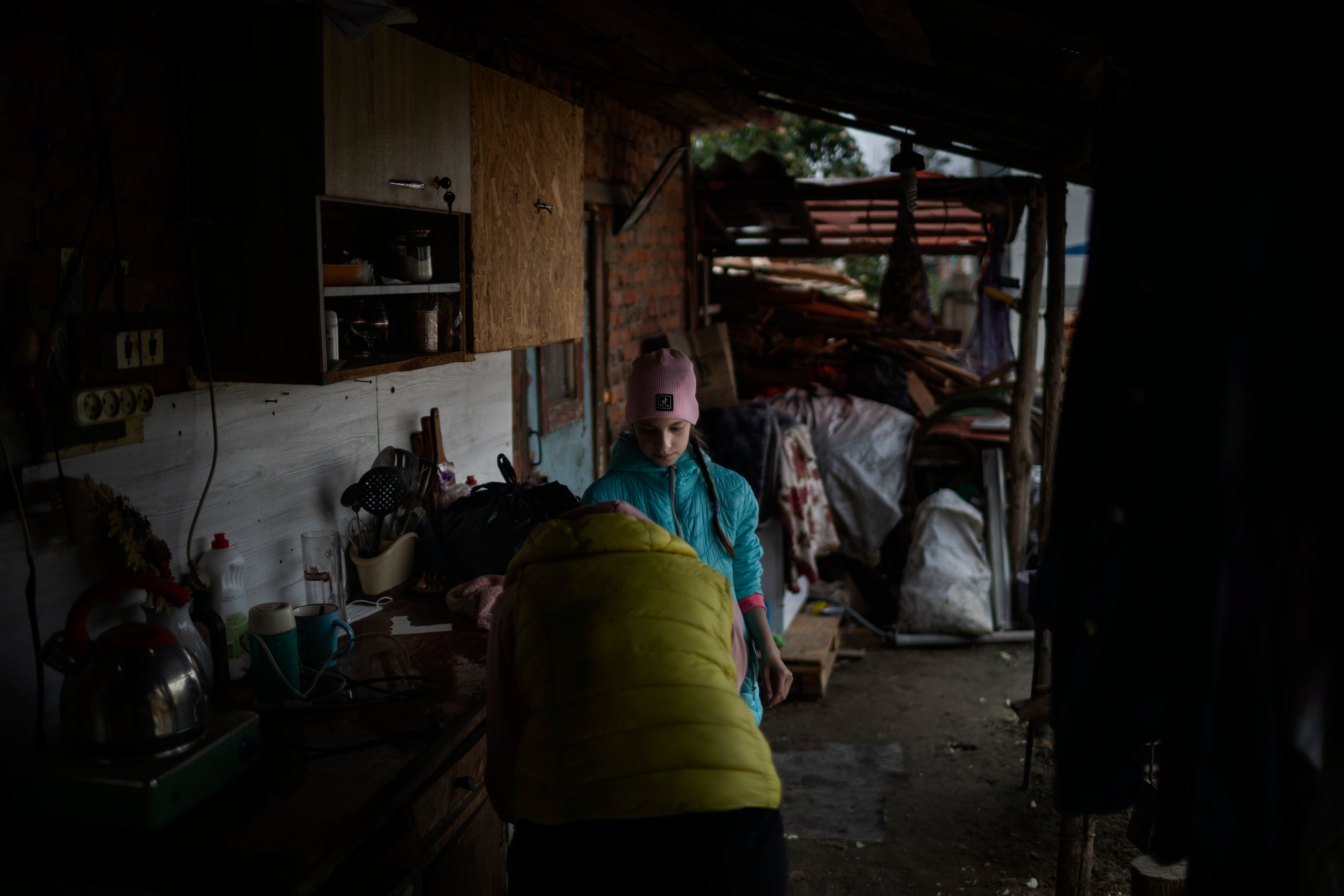 Veronika, 9, helps her mother Tetiana clean their bombed home