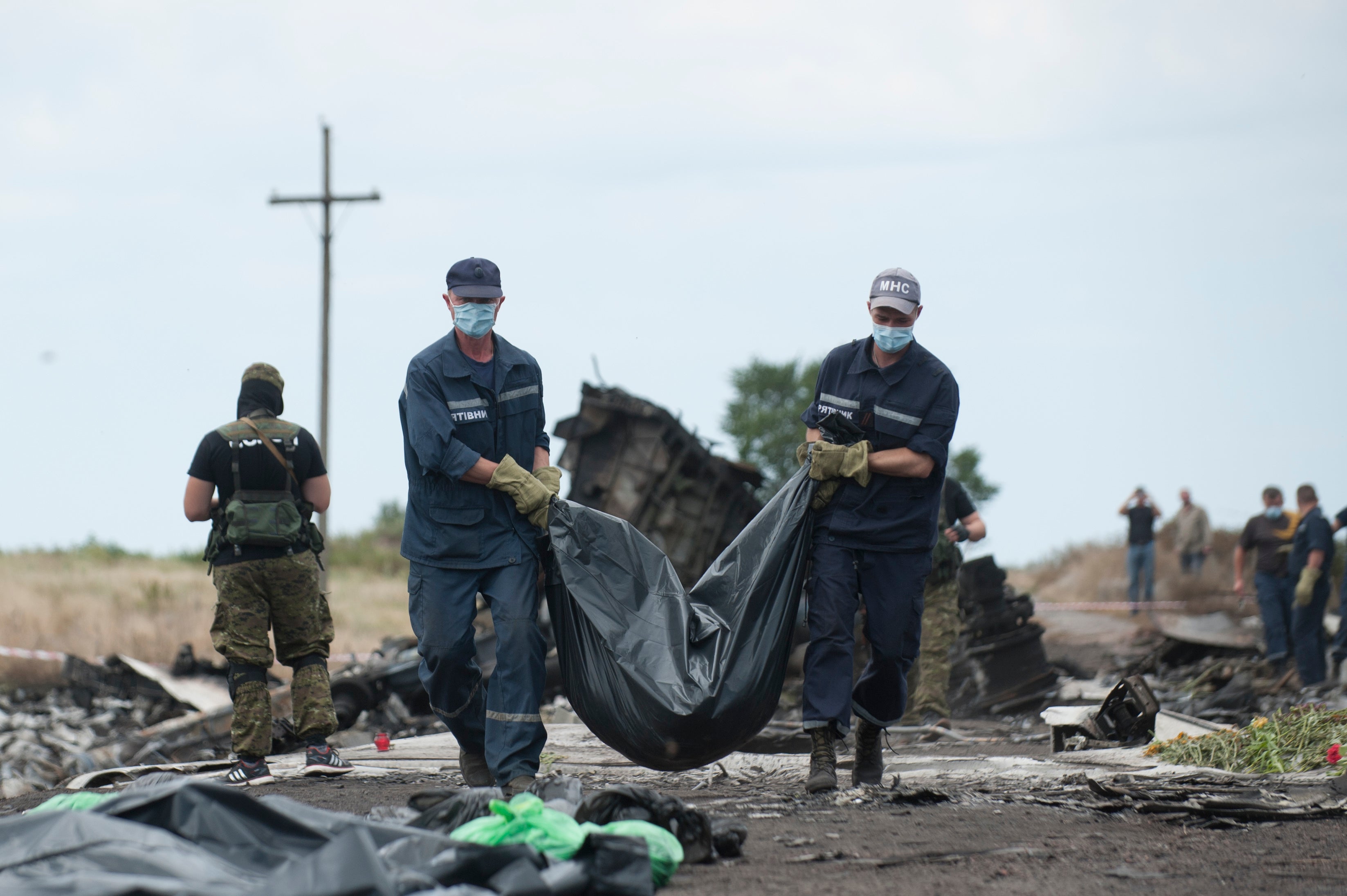 Emergency workers carry a body away from the crash scene