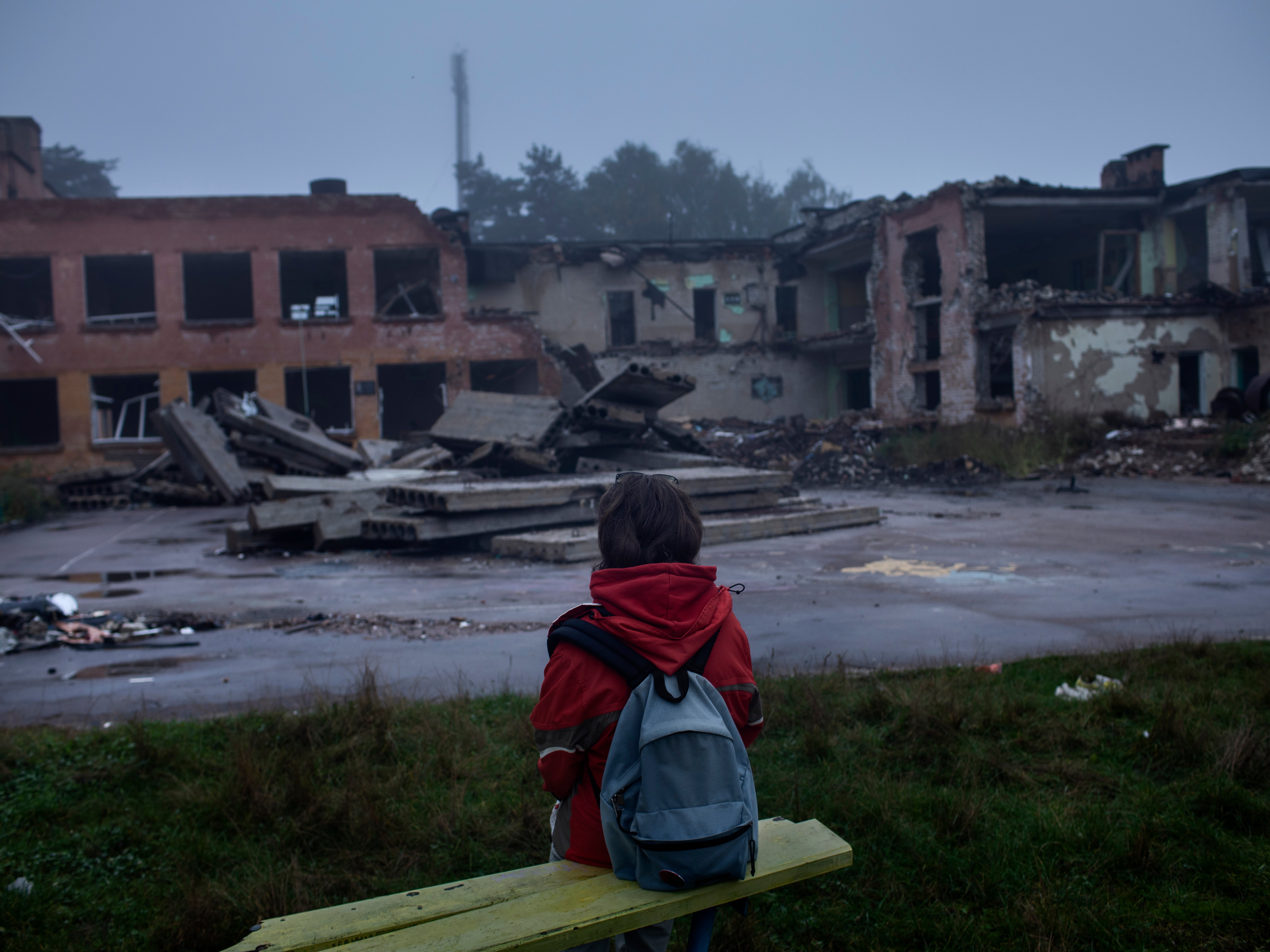 Darya Nikolayenko, 14, sits looking at his destroyed school in Chernihiv