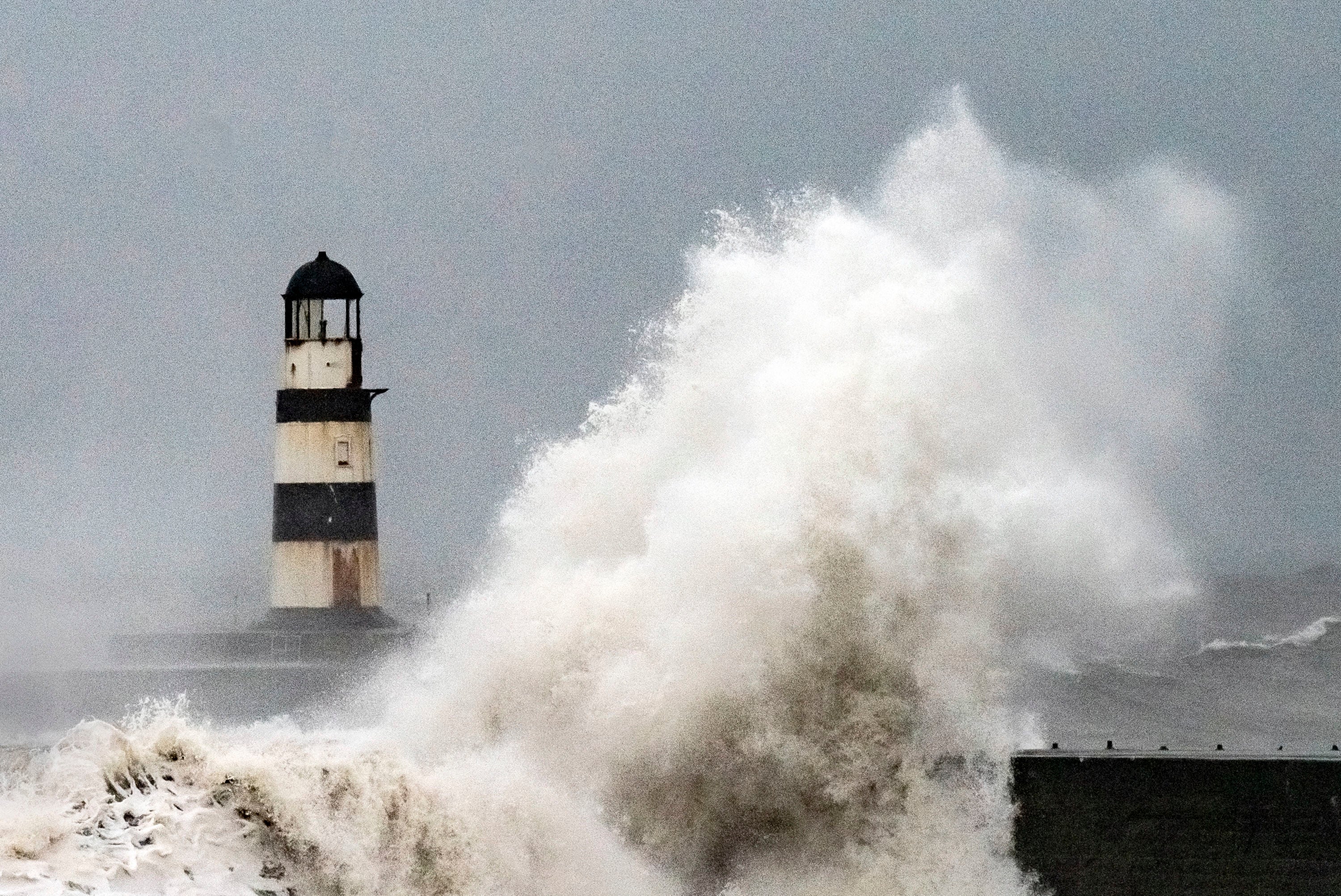 Waves crash against the lighthouse in Seaham Harbour, County Durham