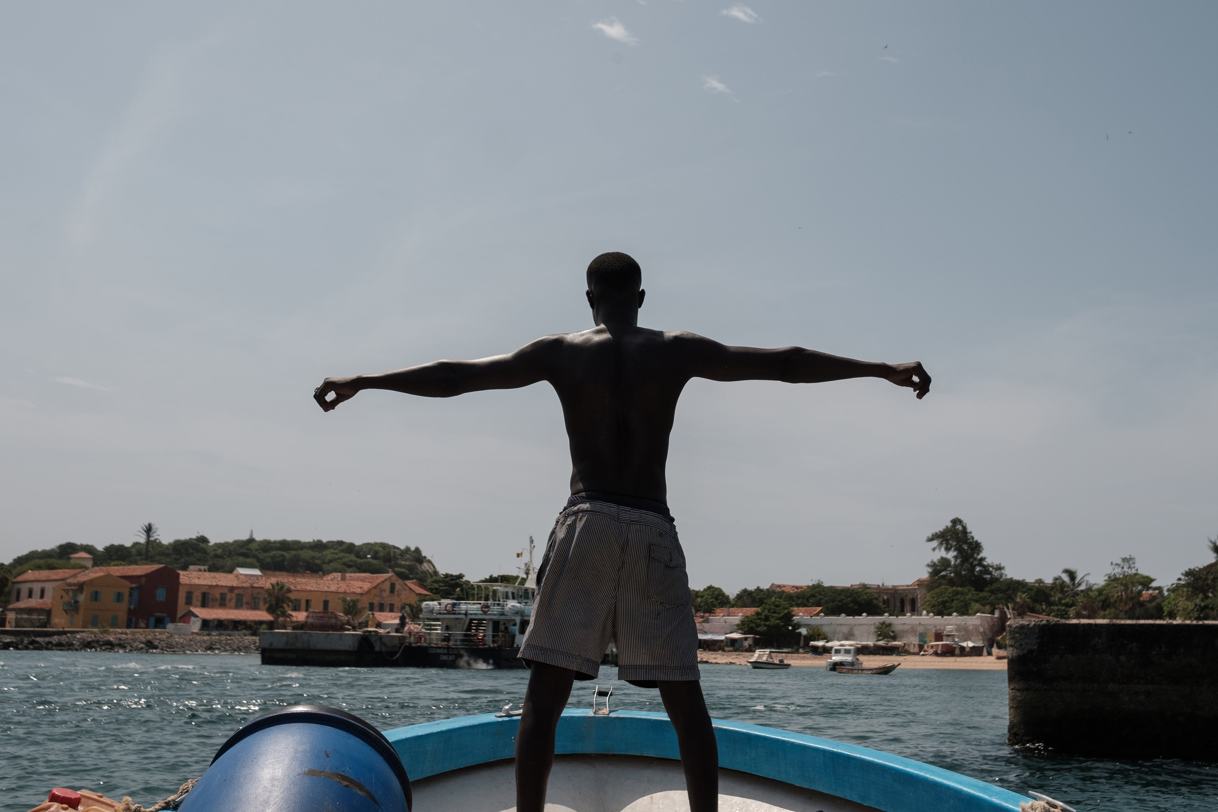 René Ndiana Faye stands at the bow of the dive boat as it comes into the harbour