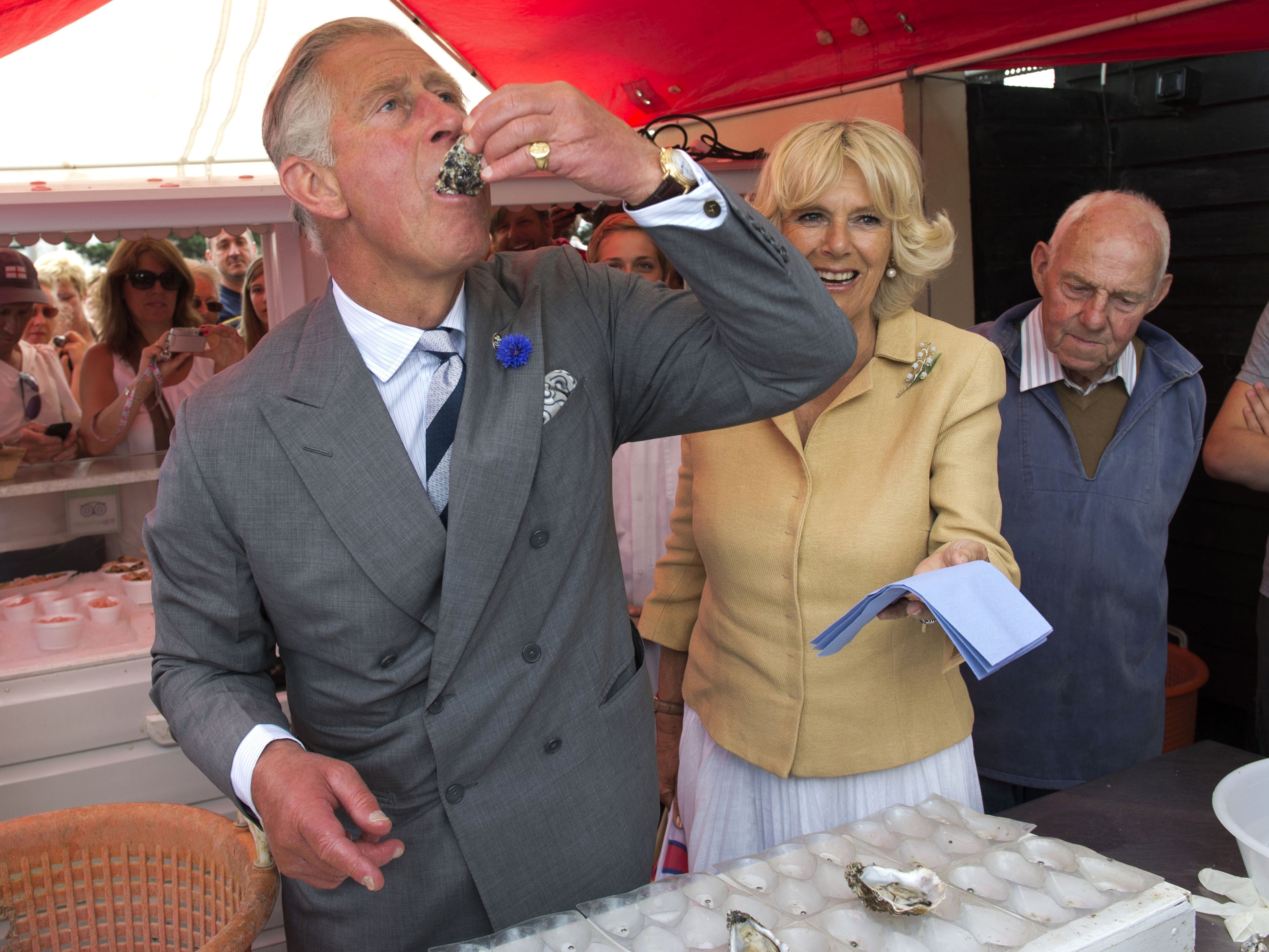 King Charles sampling an oyster with the Queen Consort in 2013