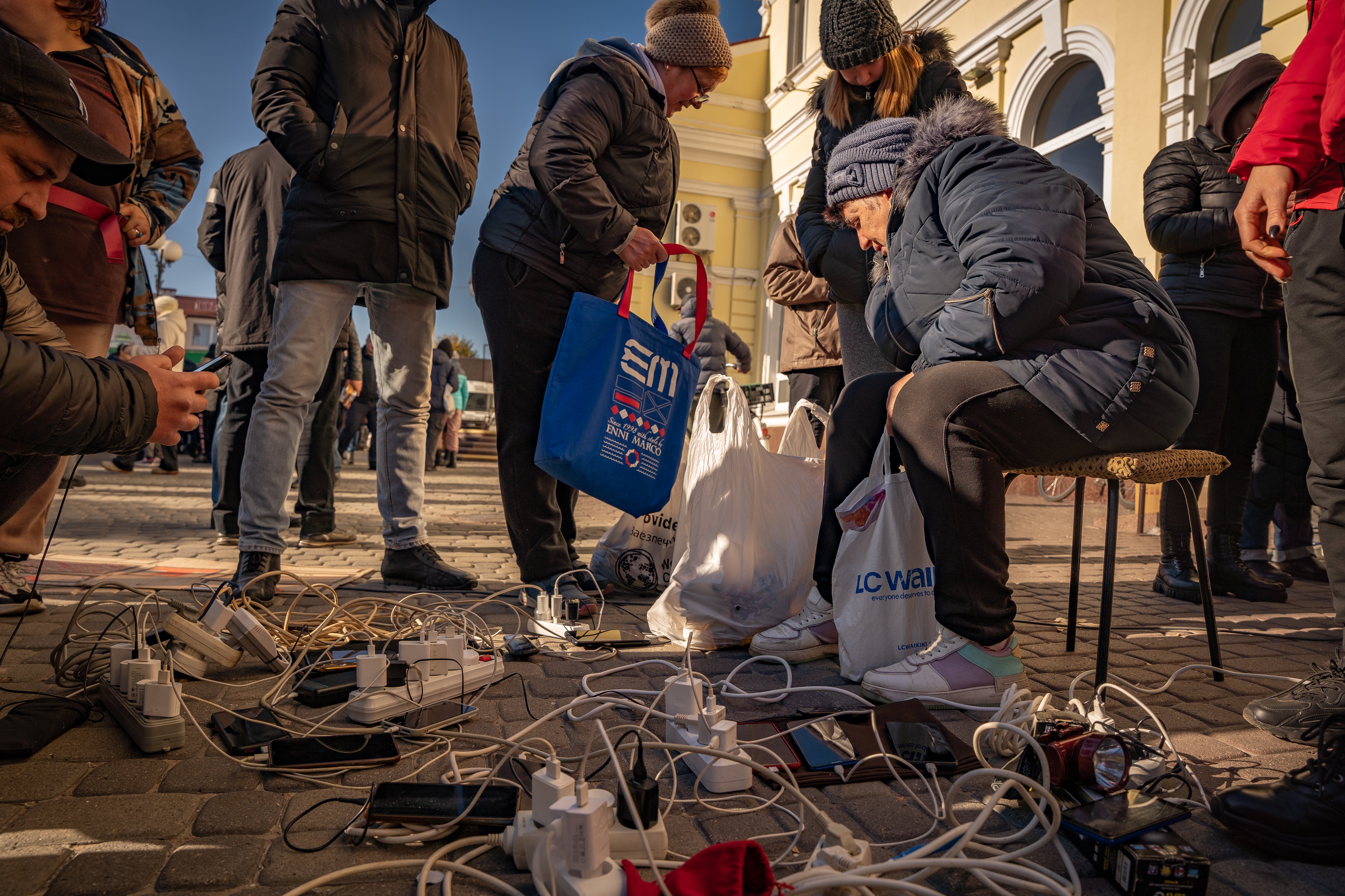 Families gather to charge their phones at Kherson train station