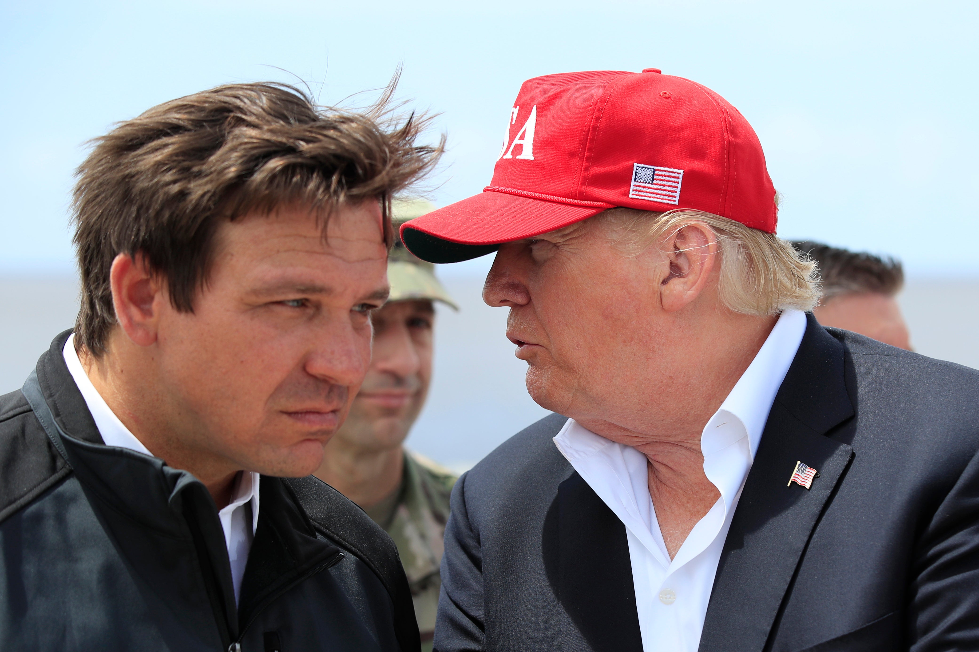 President Donald Trump talks to Florida Gov. Ron DeSantis, left, during a visit to Lake Okeechobee and Herbert Hoover Dike at Canal Point, Fla., March 29, 2019.