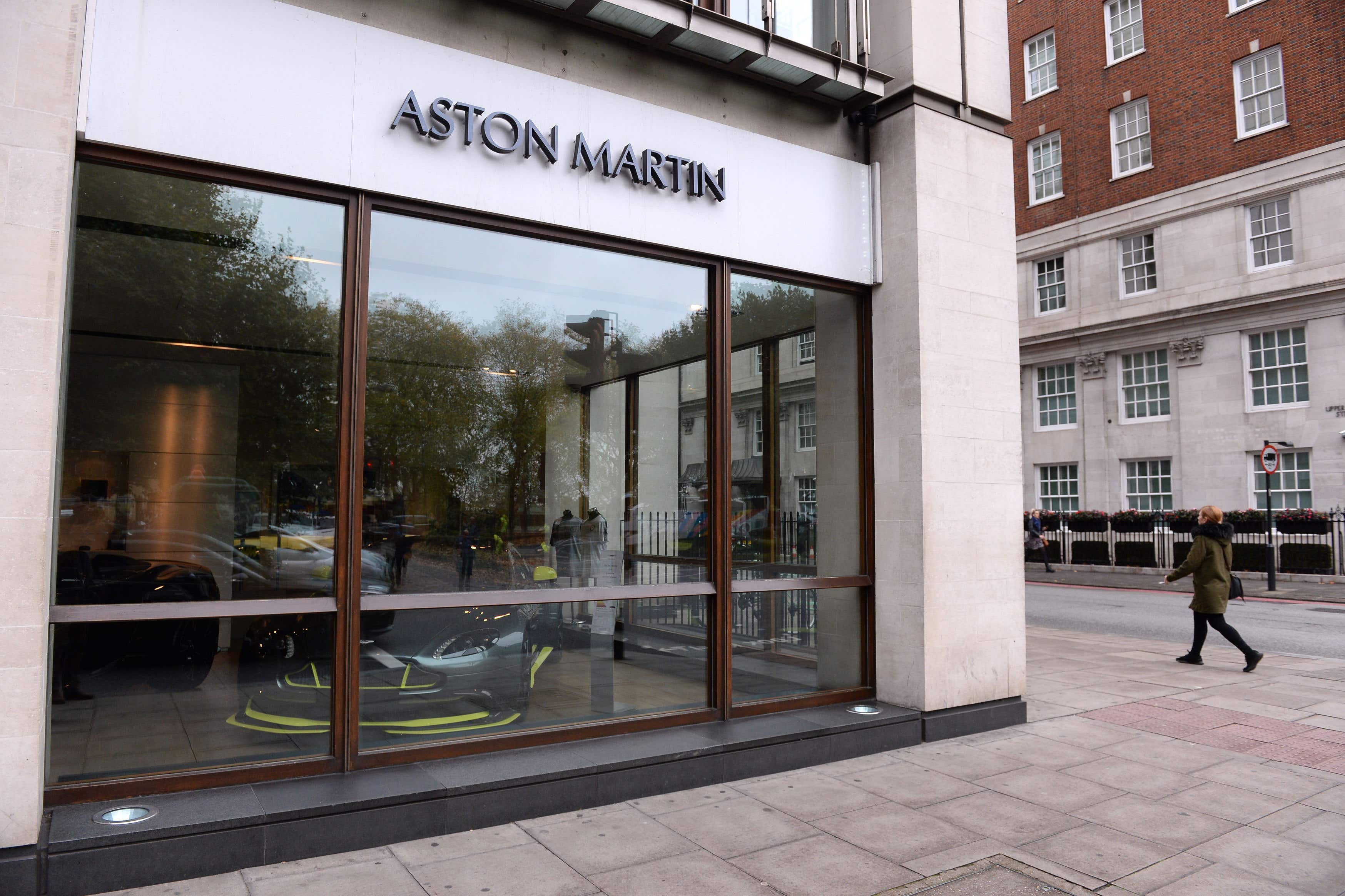 A person walks past the window of Stratstone’s Aston Martin Mayfair dealership on Park Lane, London, whose parent company, Pendragon, has seen its suitor granted an extension over a possible takeover (Stefan Rousseau/PA)