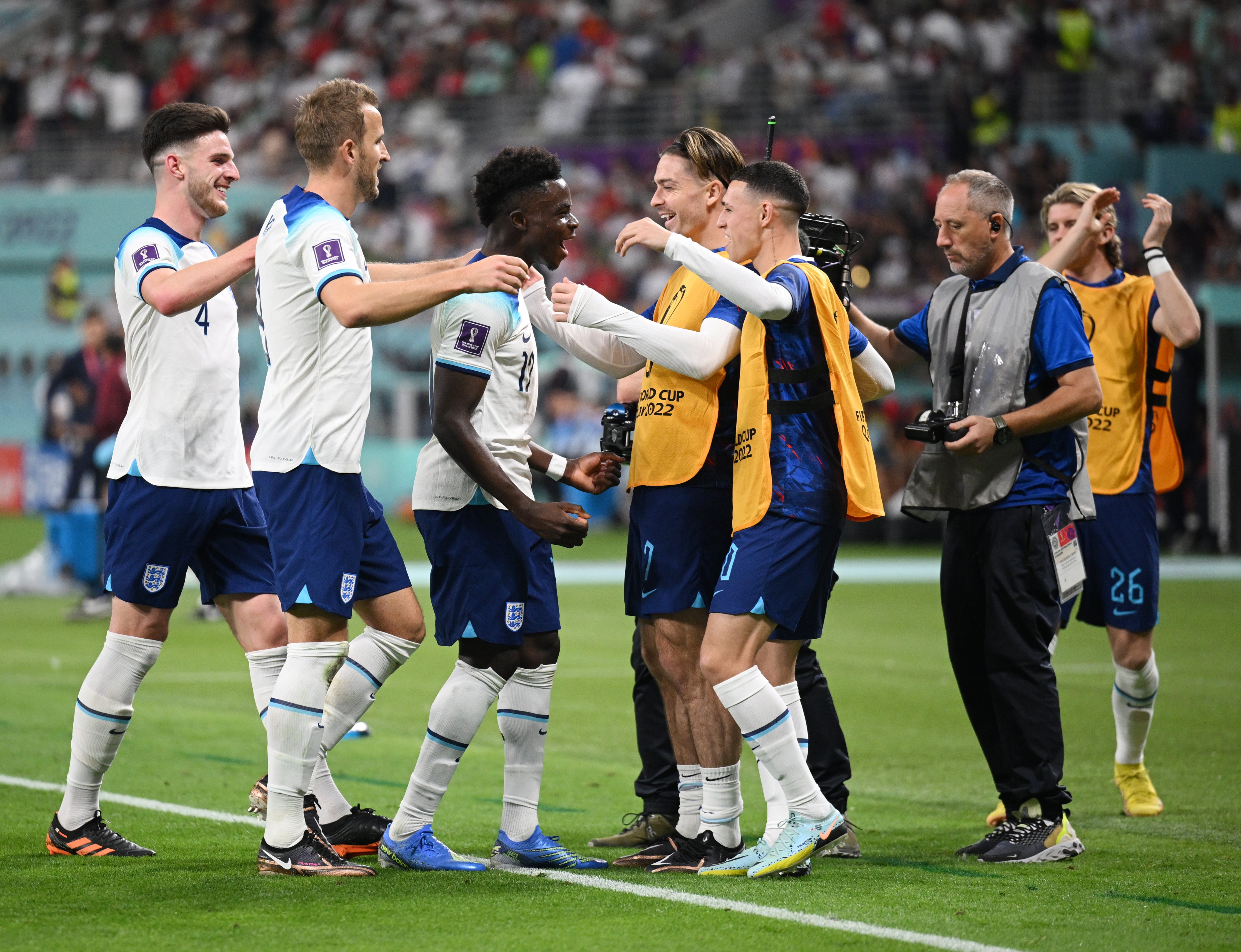 Saka celebrates his second goal of the game with England players warming up