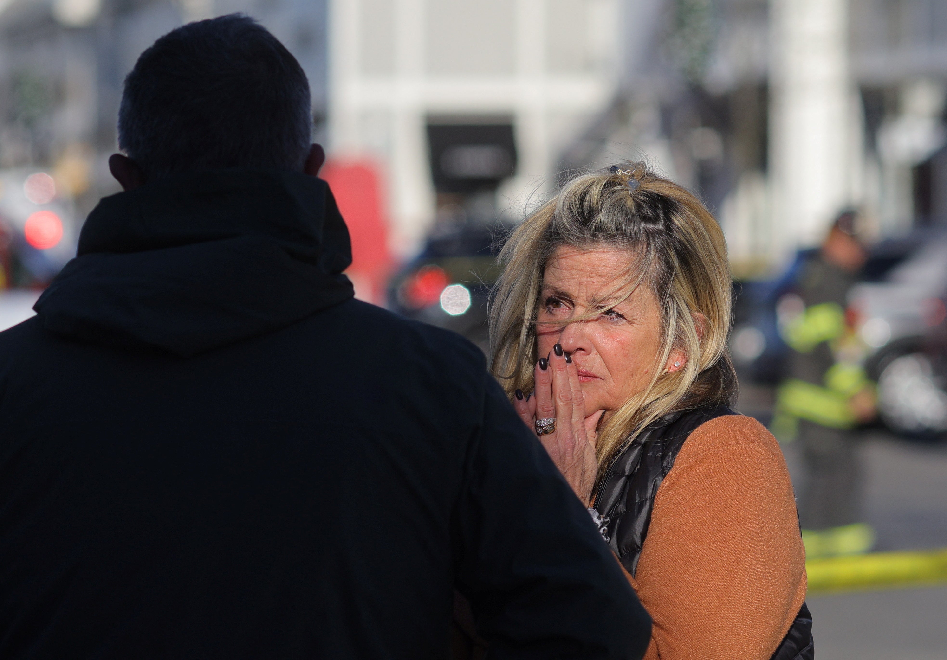 People react as emergency services personnel attend the scene after a vehicle crashed into an Apple store in Hingham, Massachusetts, U.S. November 21, 2022