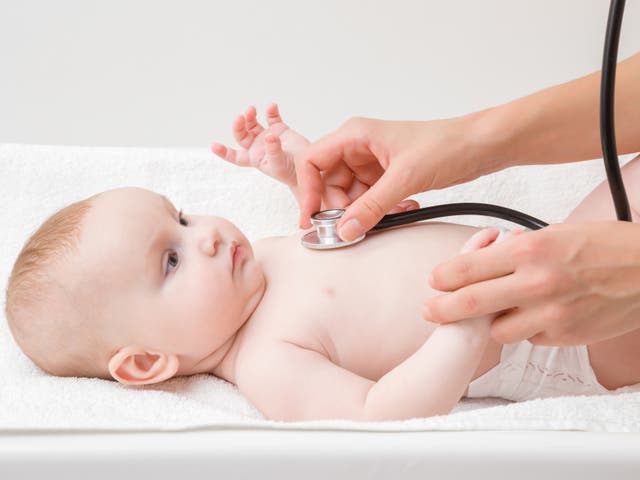 <p>A baby being examined by a paediatrician in hospital</p>