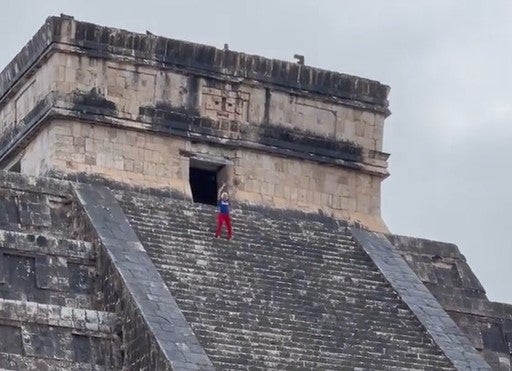 Tourist appears to mock the 'no climbing' rule with a little dance at the top