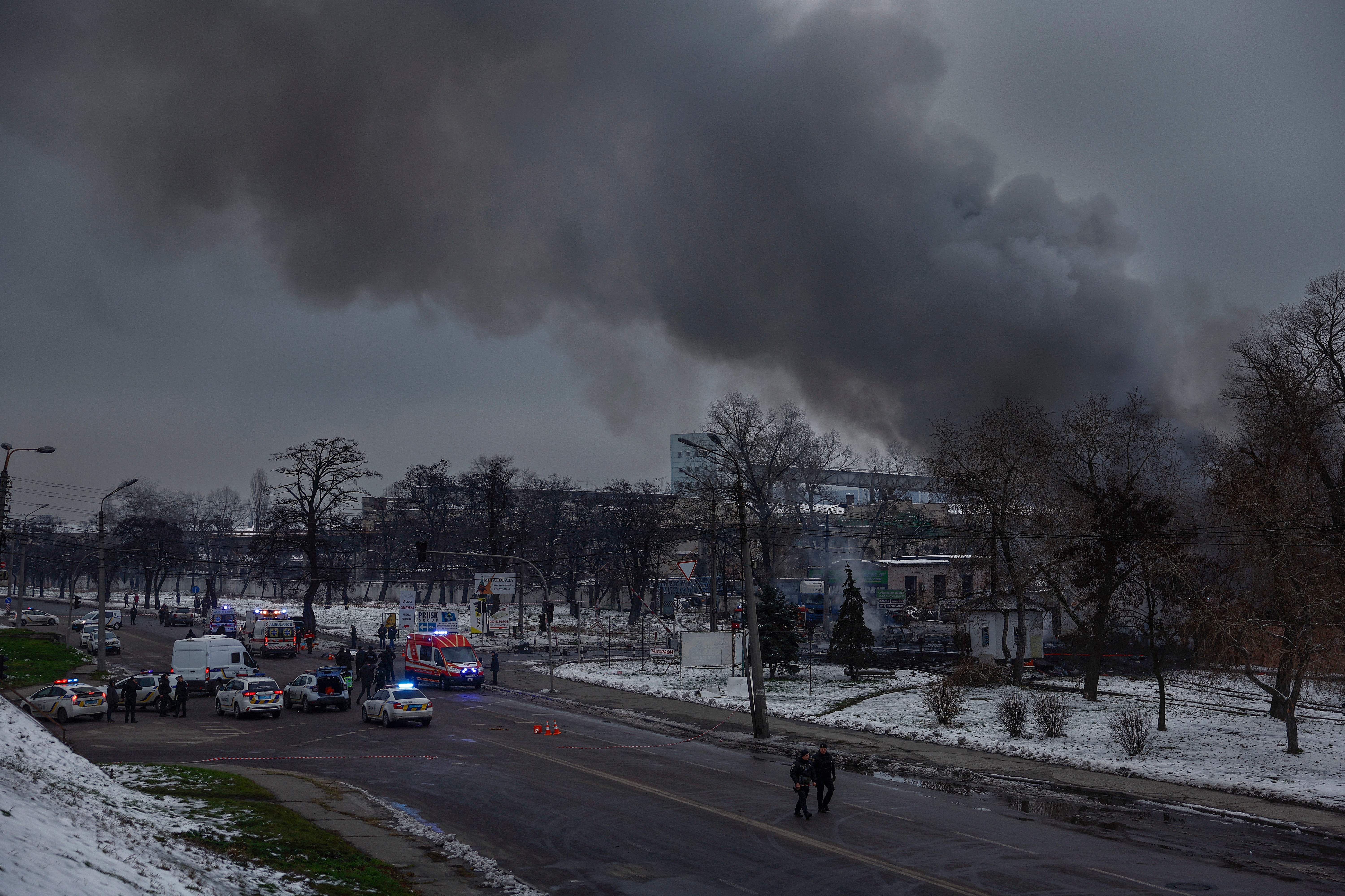 Fire and rescue workers attend a building hit by a missile in central Kyiv