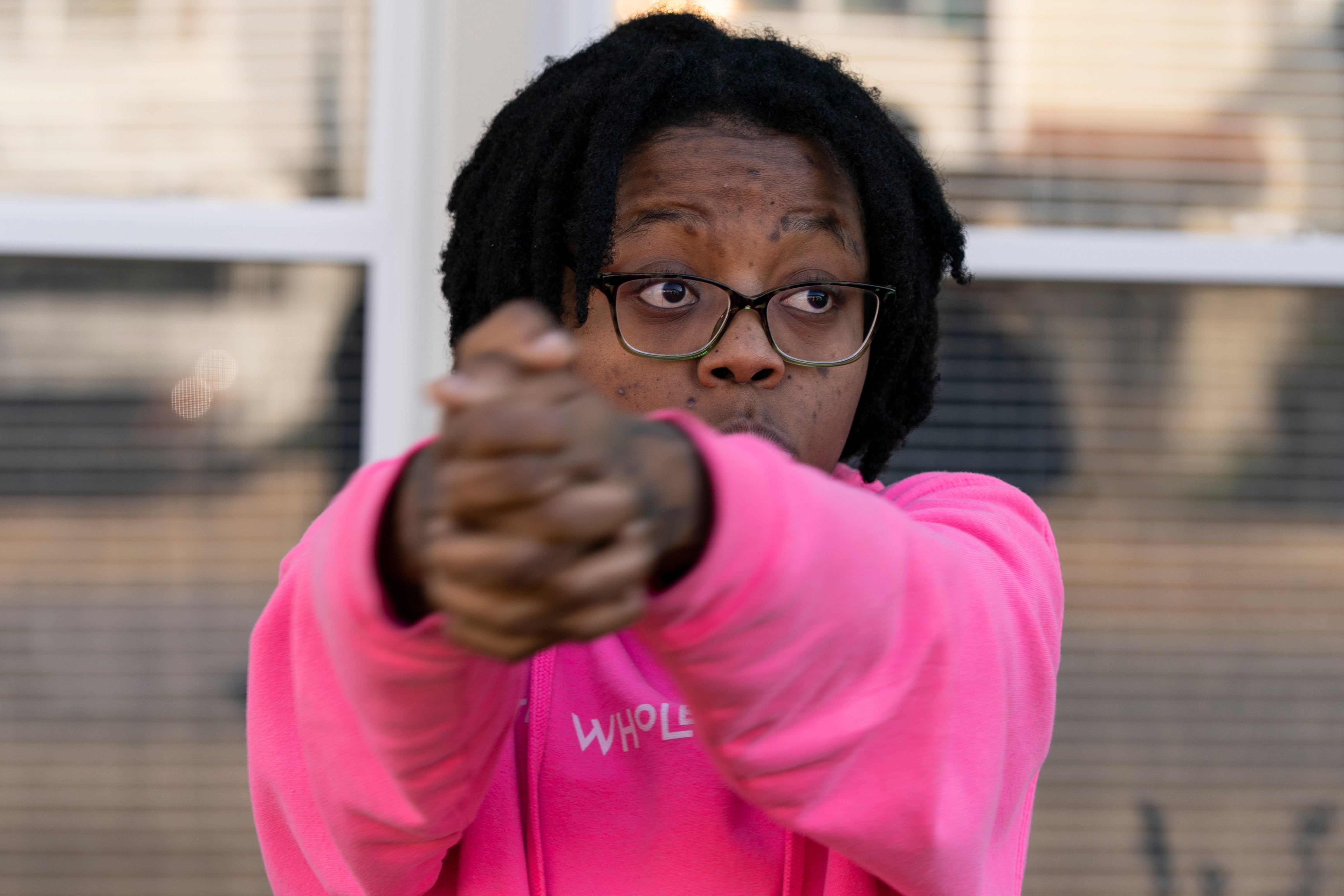 Coworker Briana Tyler uses her hands like a gun to demonstrate how the gunman at the Walmart in Chesapeake