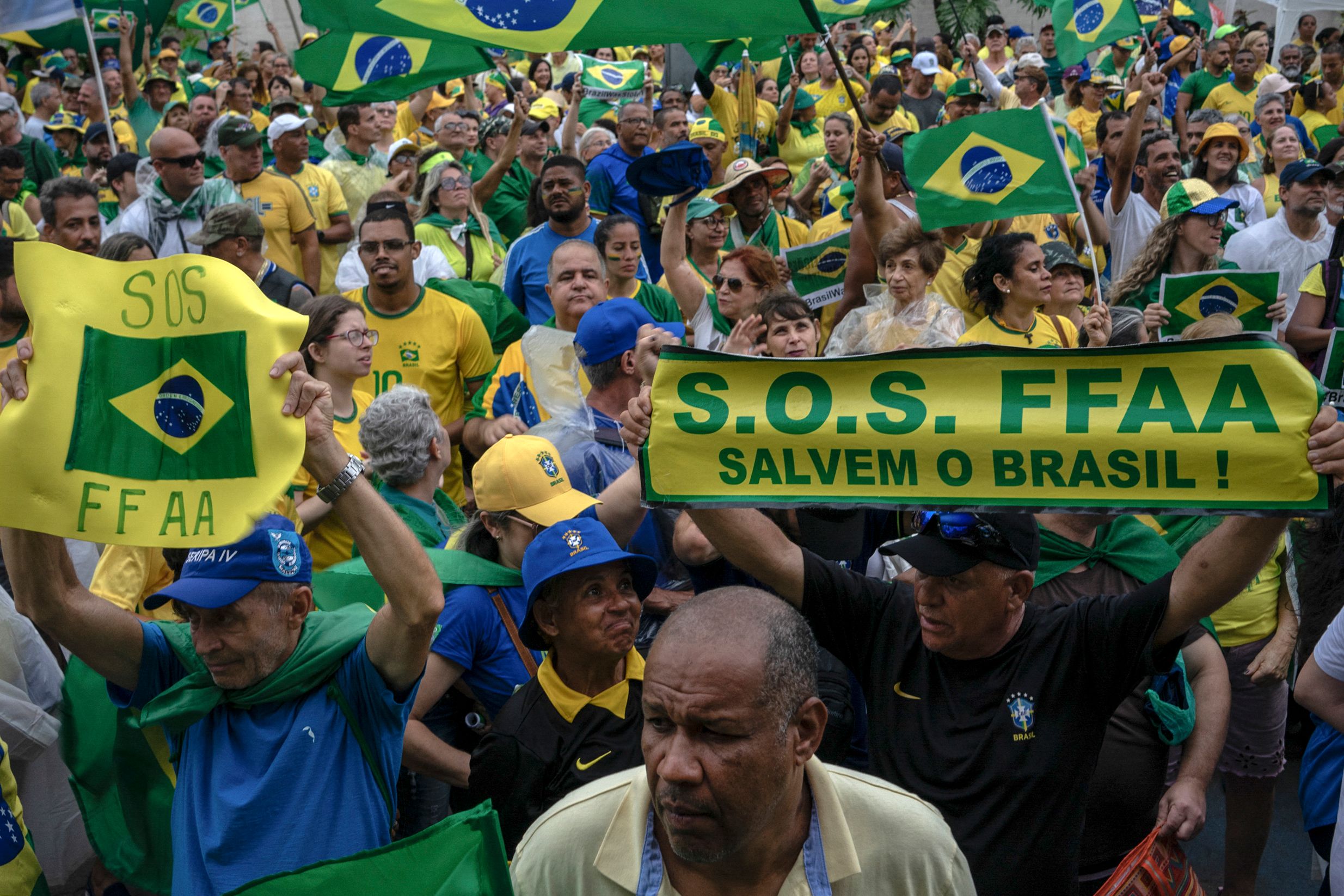 Supporters of Brazilian president Jair Bolsonaro hold signs asking for military intervention during a demonstration against the results of the runoff election, in front of the Eastern Military Command (CML) headquarters, downtown Rio de Janeiro, Brazil