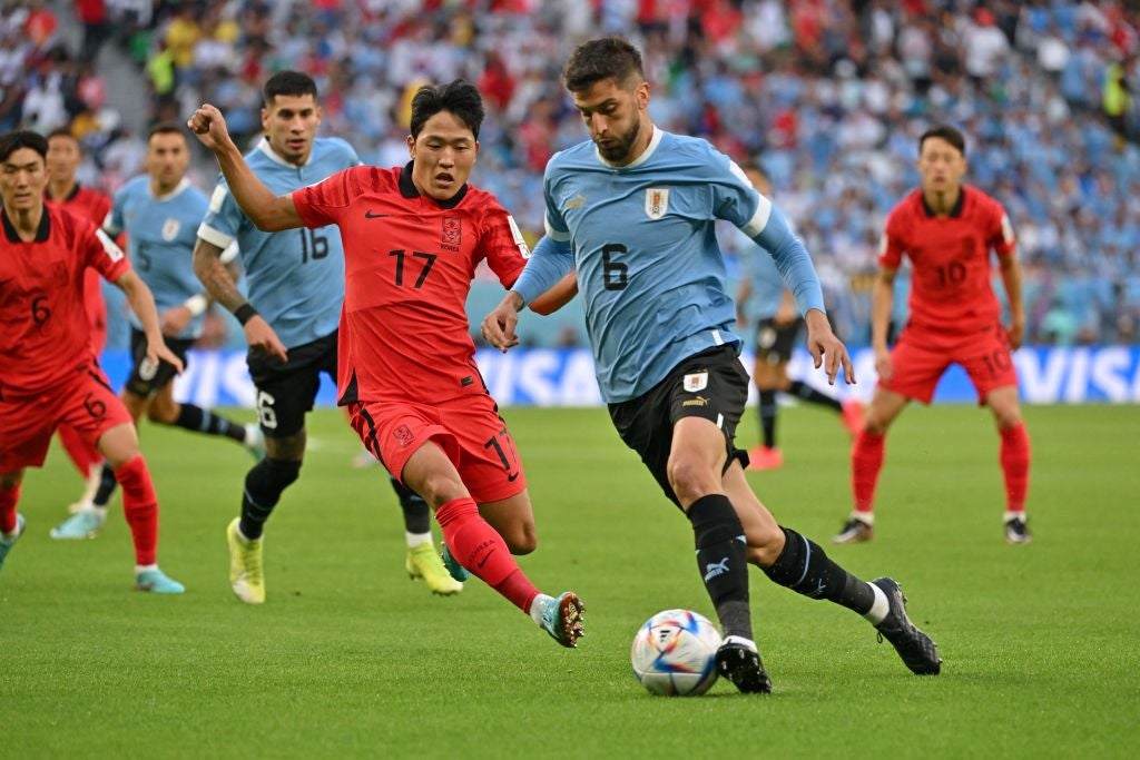 Rodrigo Bentancur runs with the ball past South Korea's midfielder Na Sang-ho