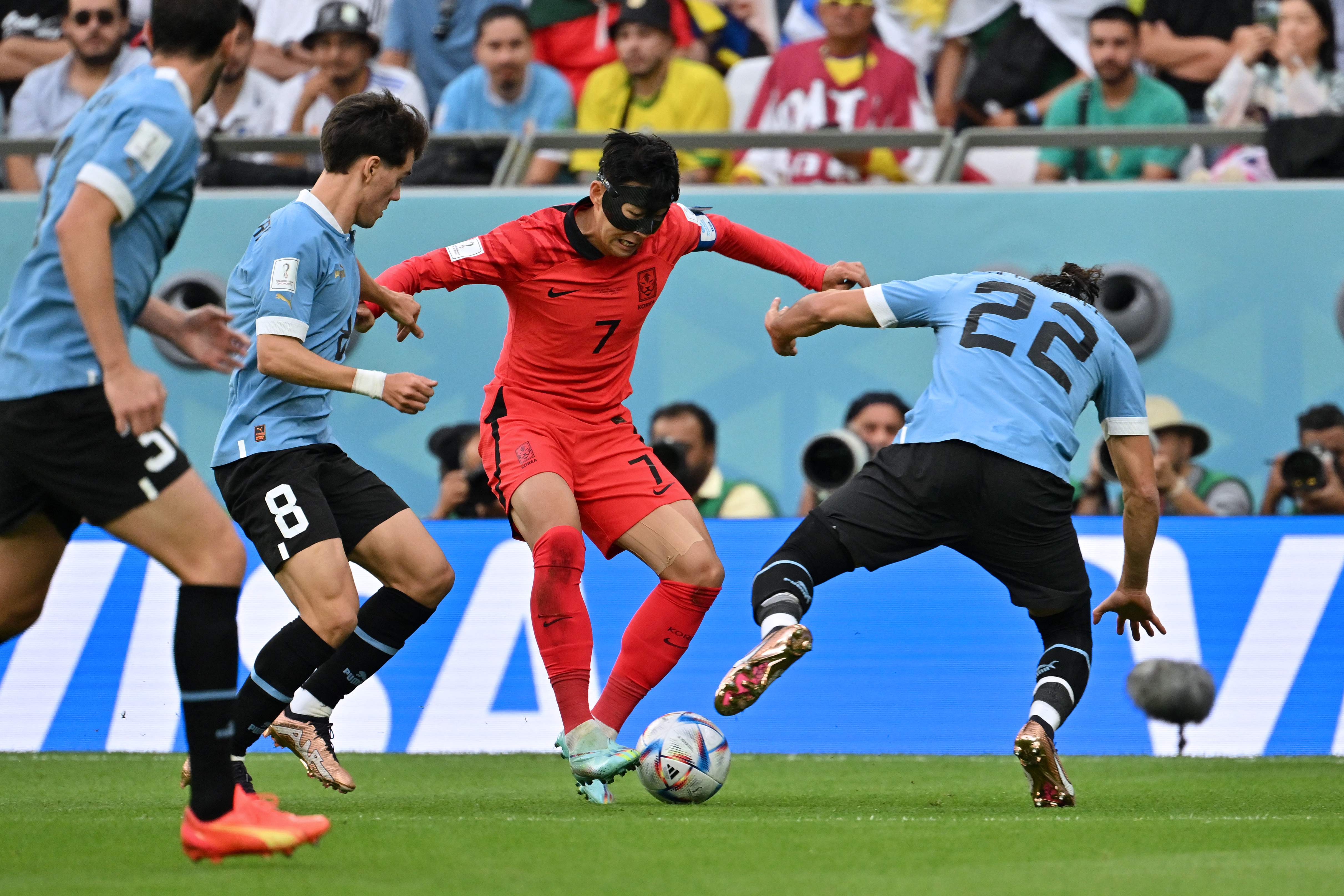 Son Heung-min fights for the ball with Uruguay's defender Martin Caceres