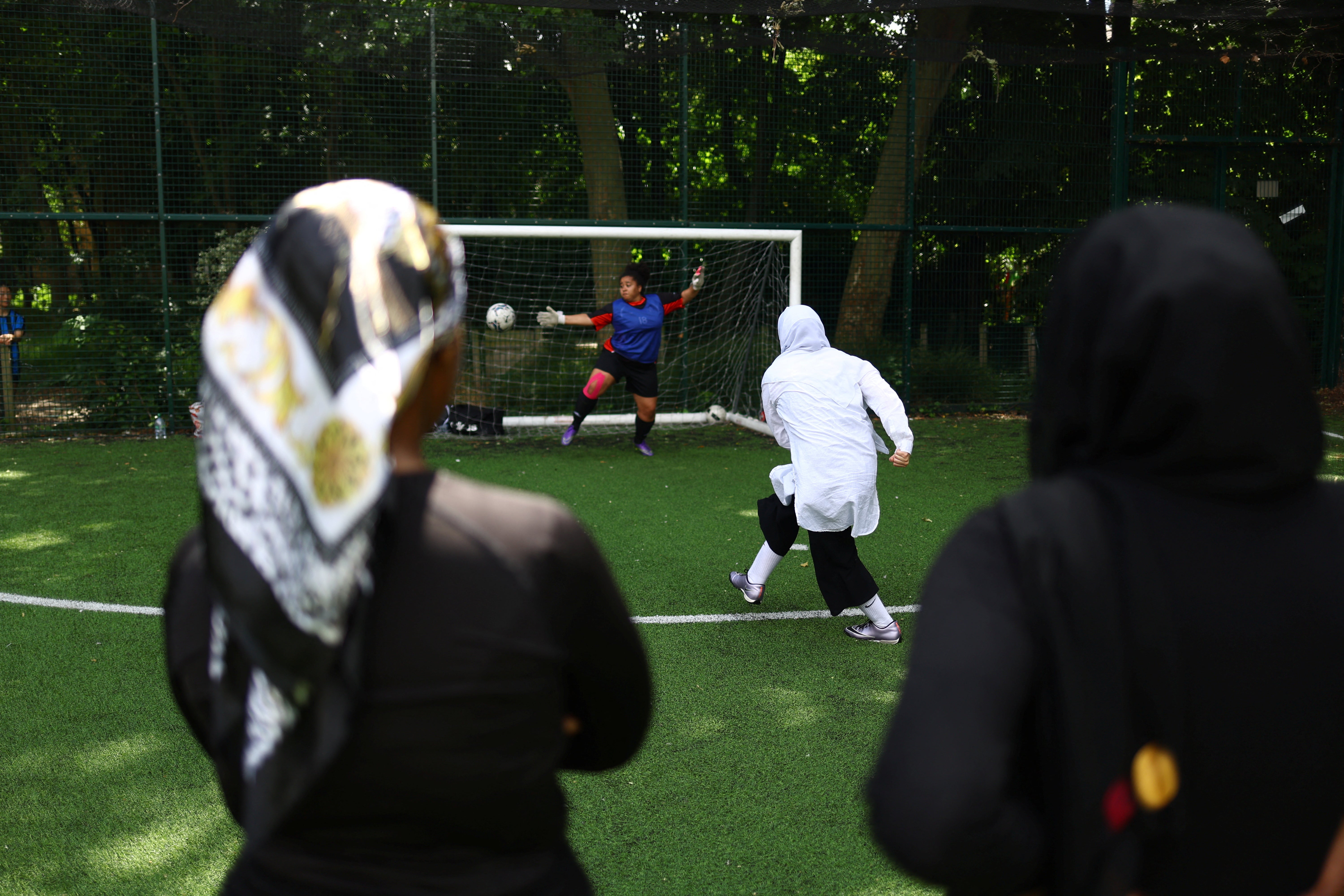 Faezeh scores a penalty during a friendly football match