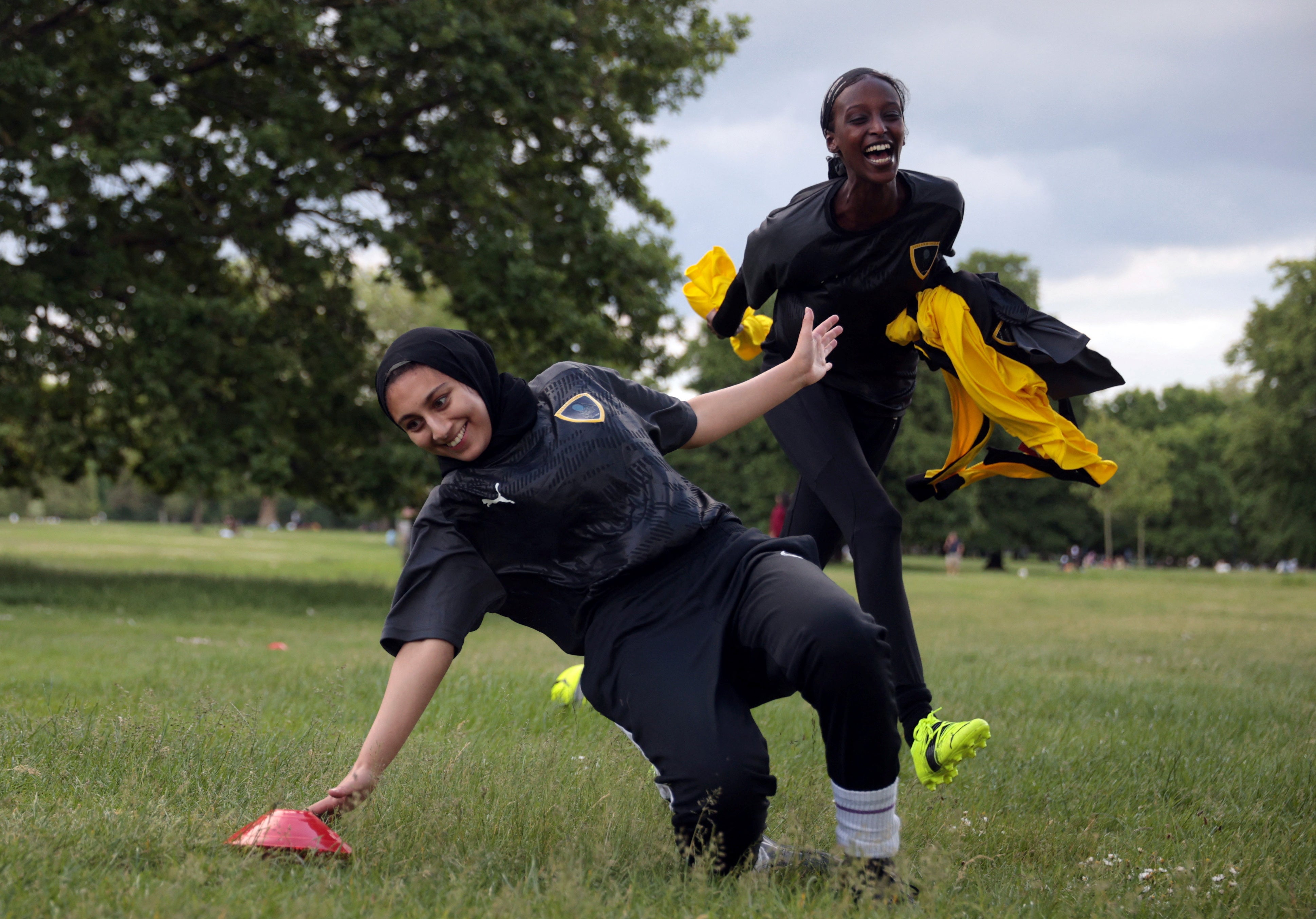 Yasmin chases her teammate Assma Asif, 25, during a training session in Hyde Park