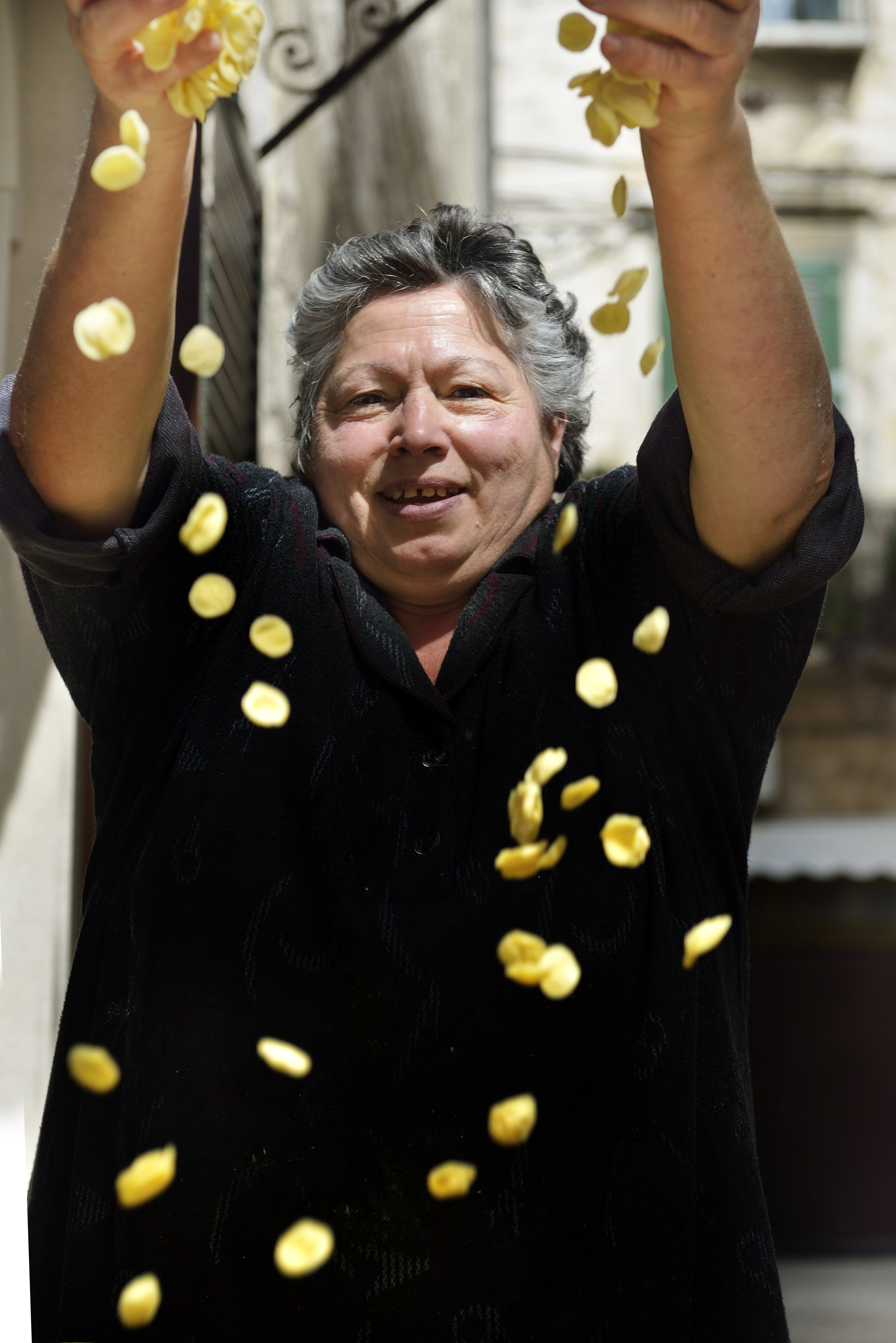 A woman makes pasta along Strada della Orecchiette