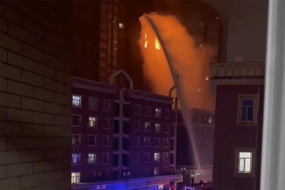 Firefighters spray water on a fire at a residential building in Urumqi in western China’s Xinjiang Uyghur Autonomous Region