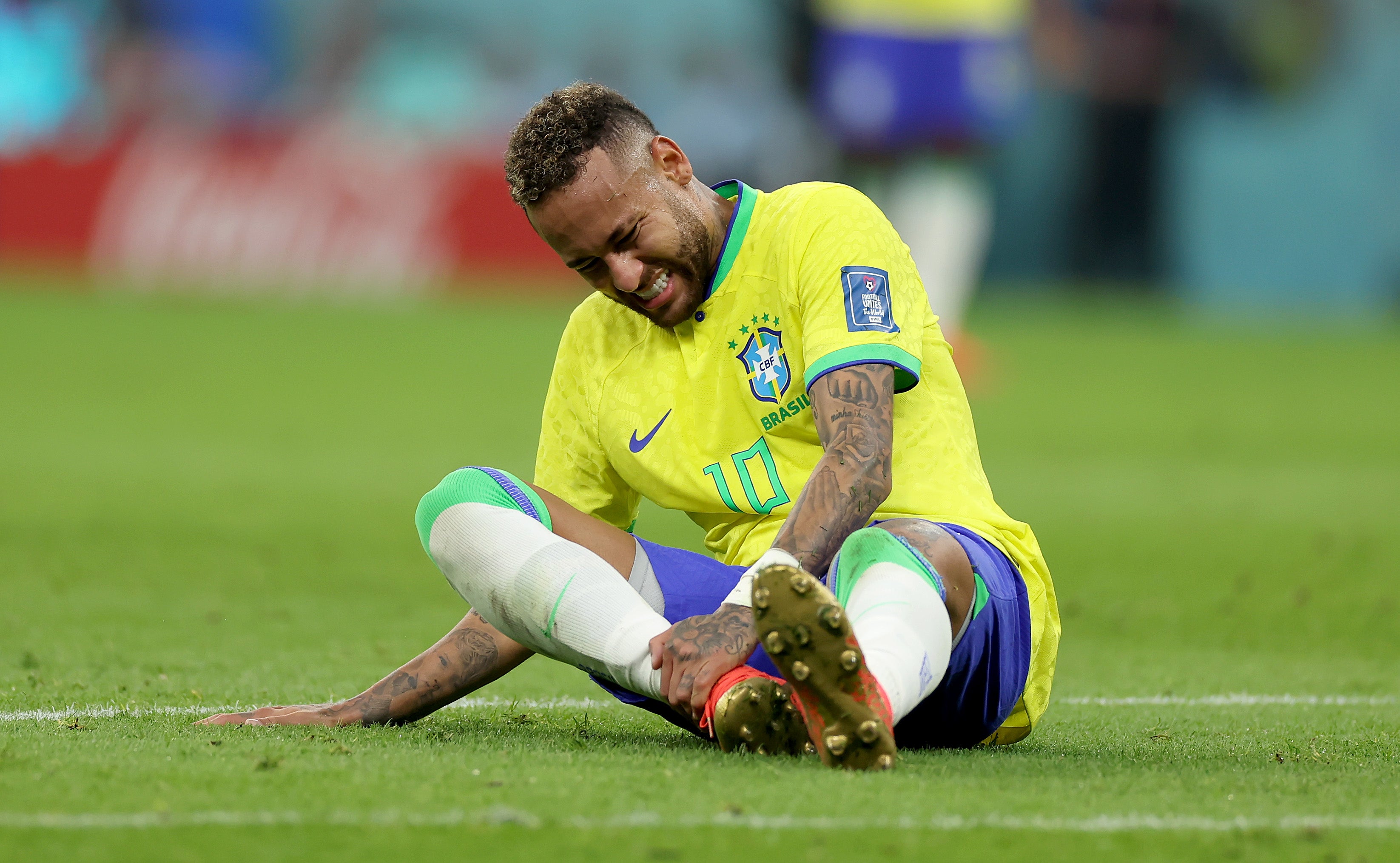 Neymar of Brazil sits injured on the pitch against Serbia