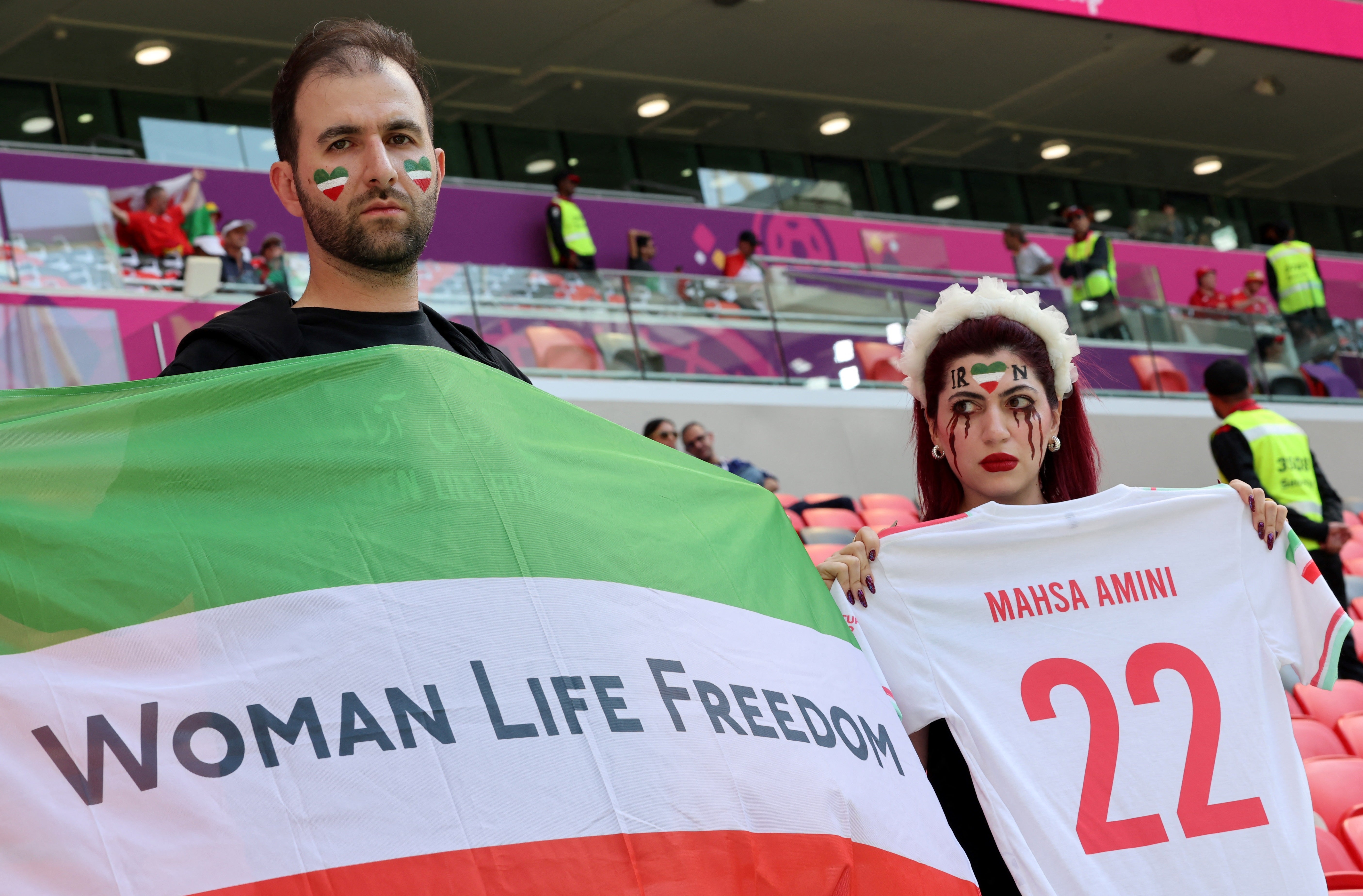 An Iran’s supporter with blood tears make up on her face holds a football jersey reading the name of Mahsa Amini, the 22-year-old Iranian Kurdish woman who died at the hospital after been arrested by the morality police for violating Iran’s strict dress code