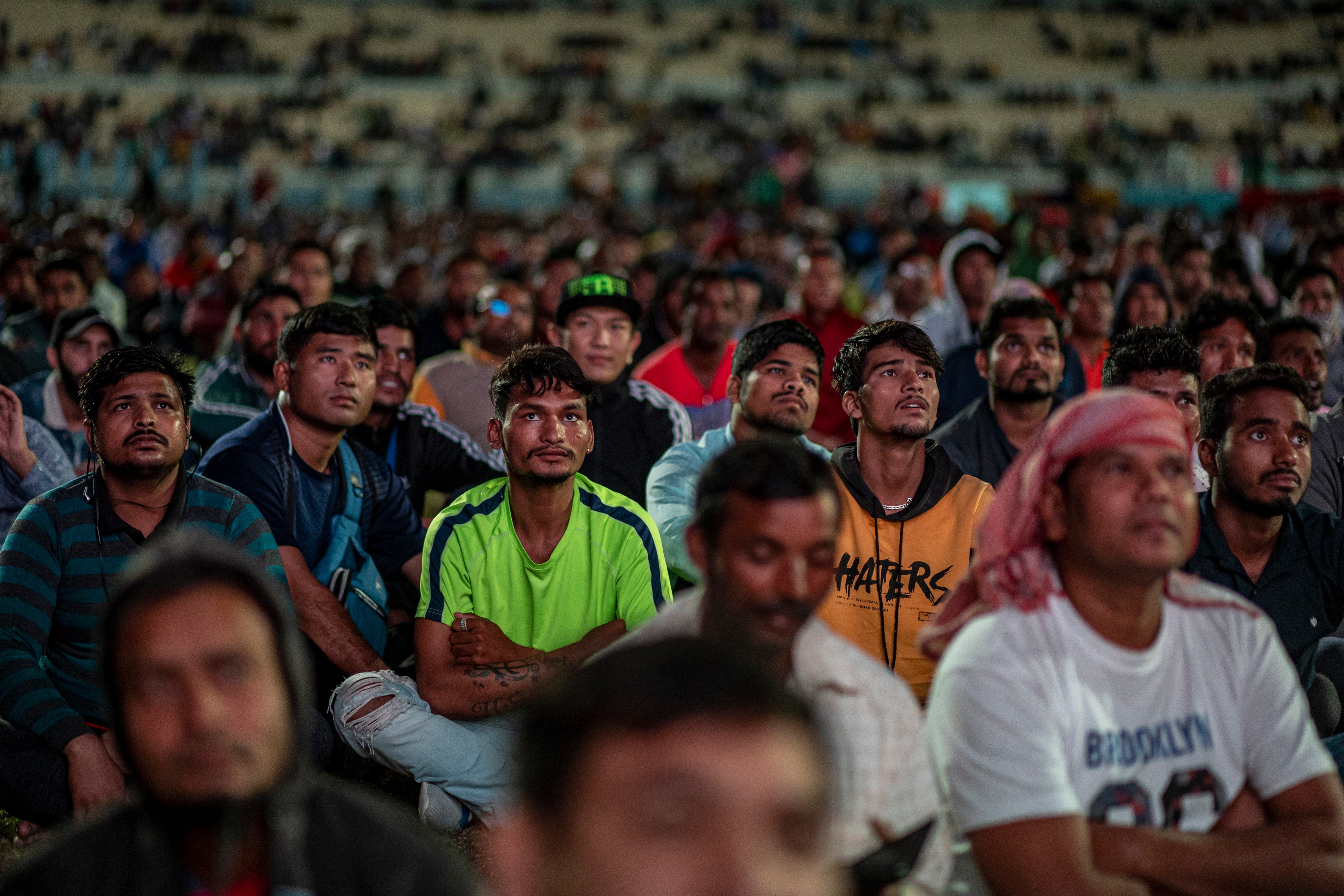 Migrant workers watch the World Cup at the at the free-entry Industrial Area Fan Zone in Doha