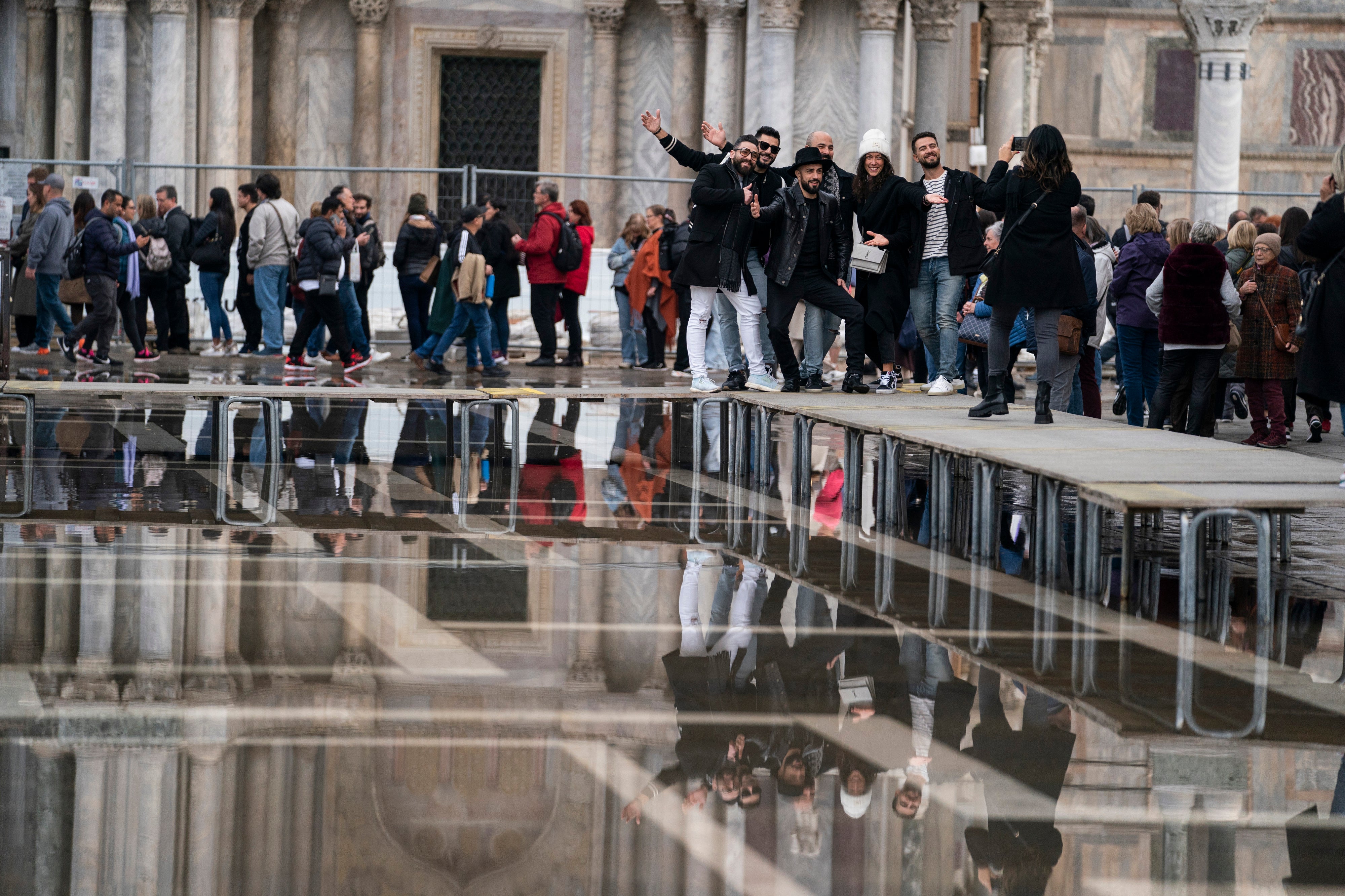 Tourists pose for a photo on one of the walkways