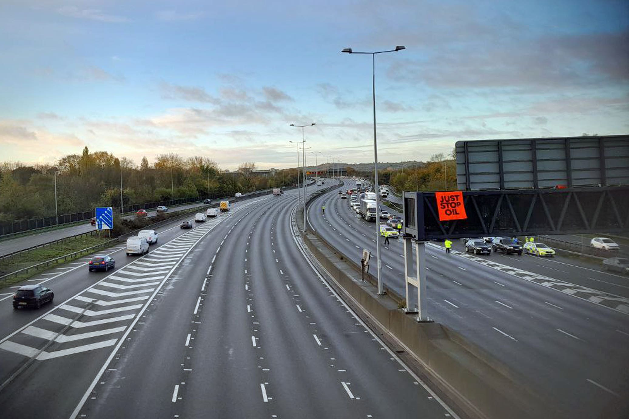 An activist on a overhead gantry on the M25 (Just Stop Oil)