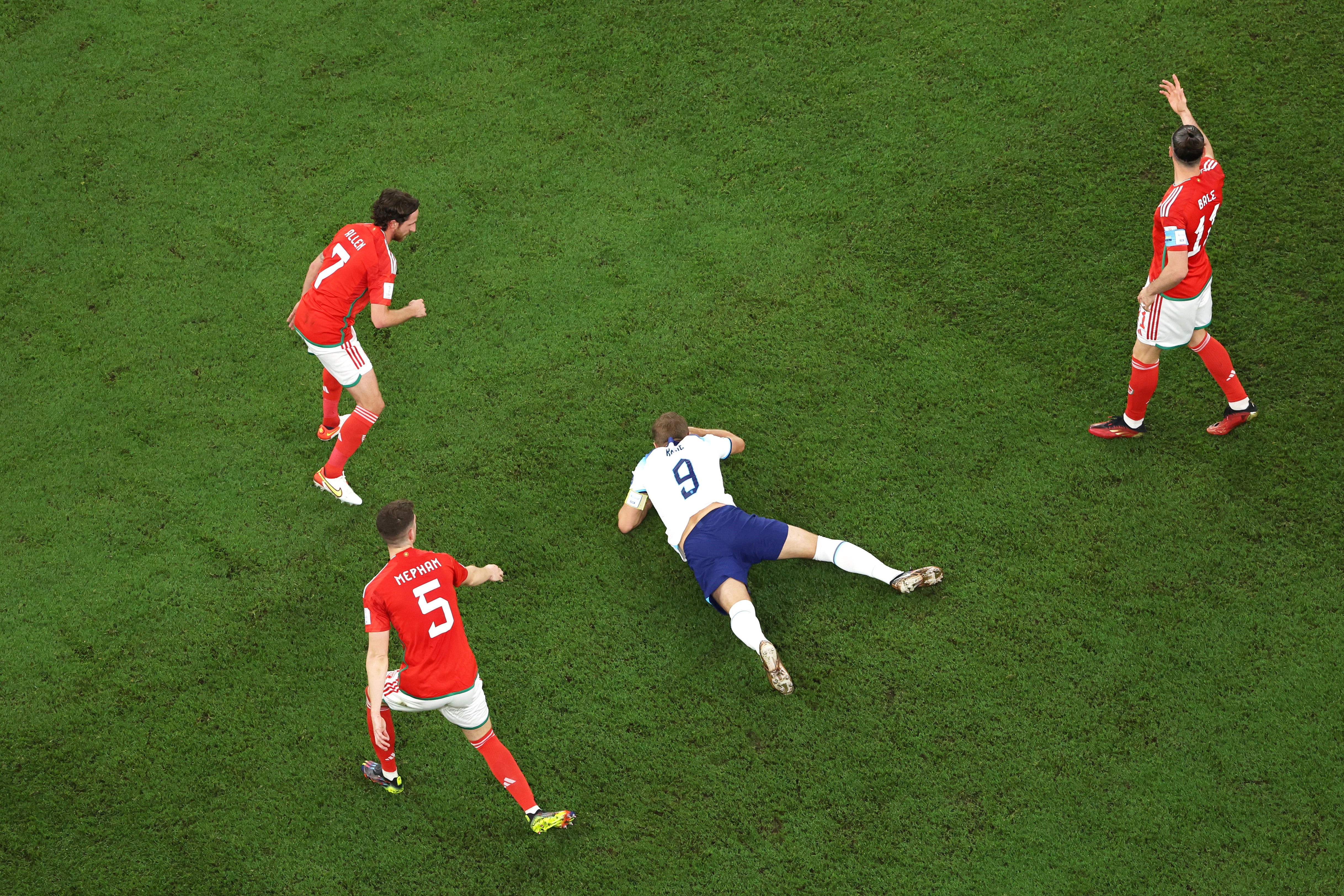 Harry Kane on the floor surrounded by Wales players