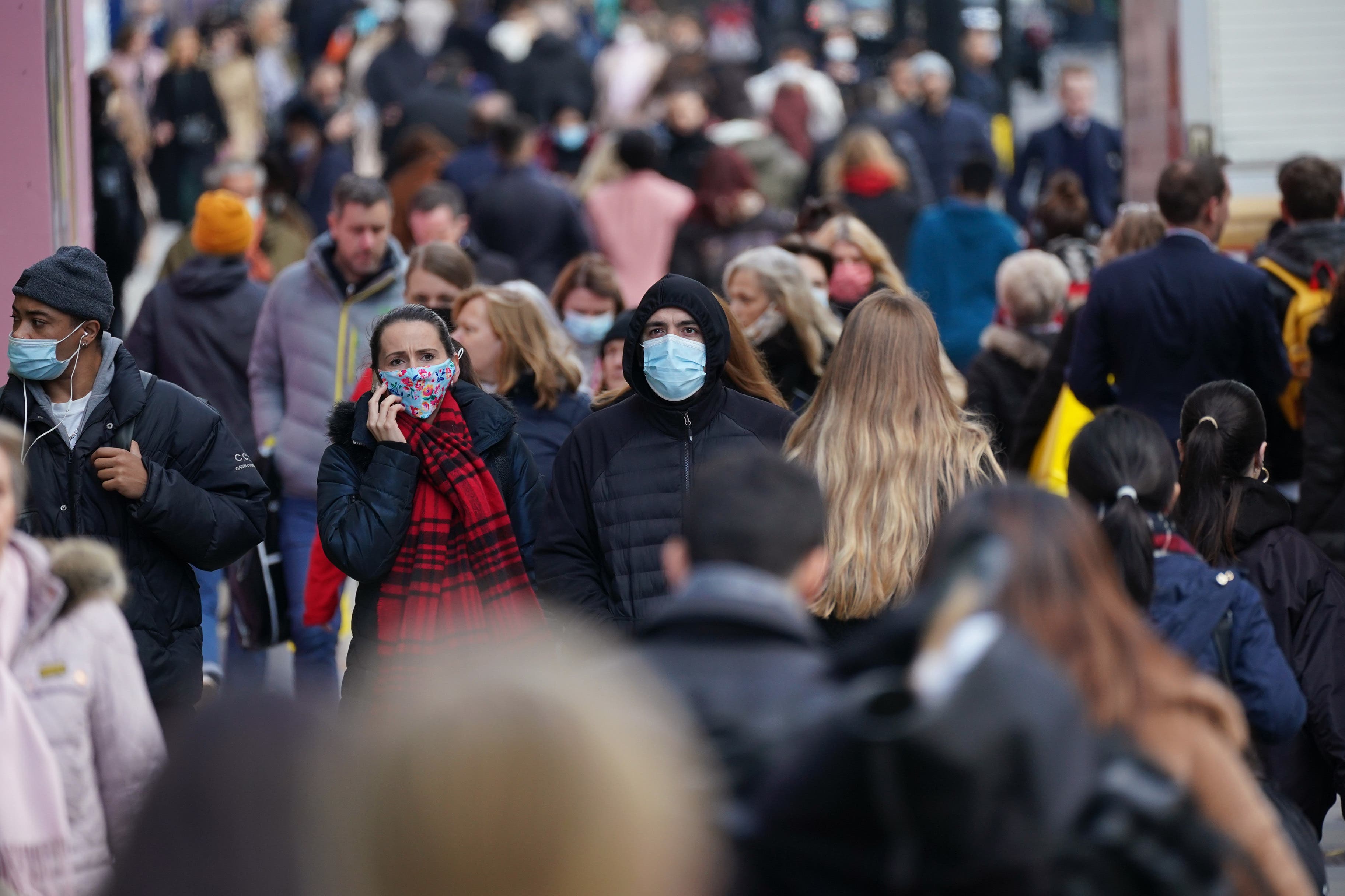 People wearing face masks walk along Oxford Street in London (Yui Mok/PA)