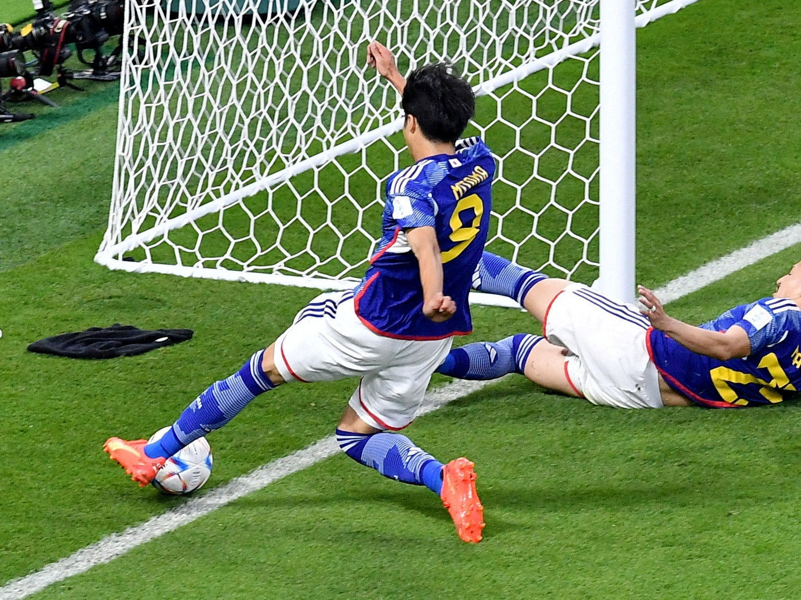 Japan's Kaoru Mitoma in action as the ball appears to cross the line before Japan's Ao Tanaka scores