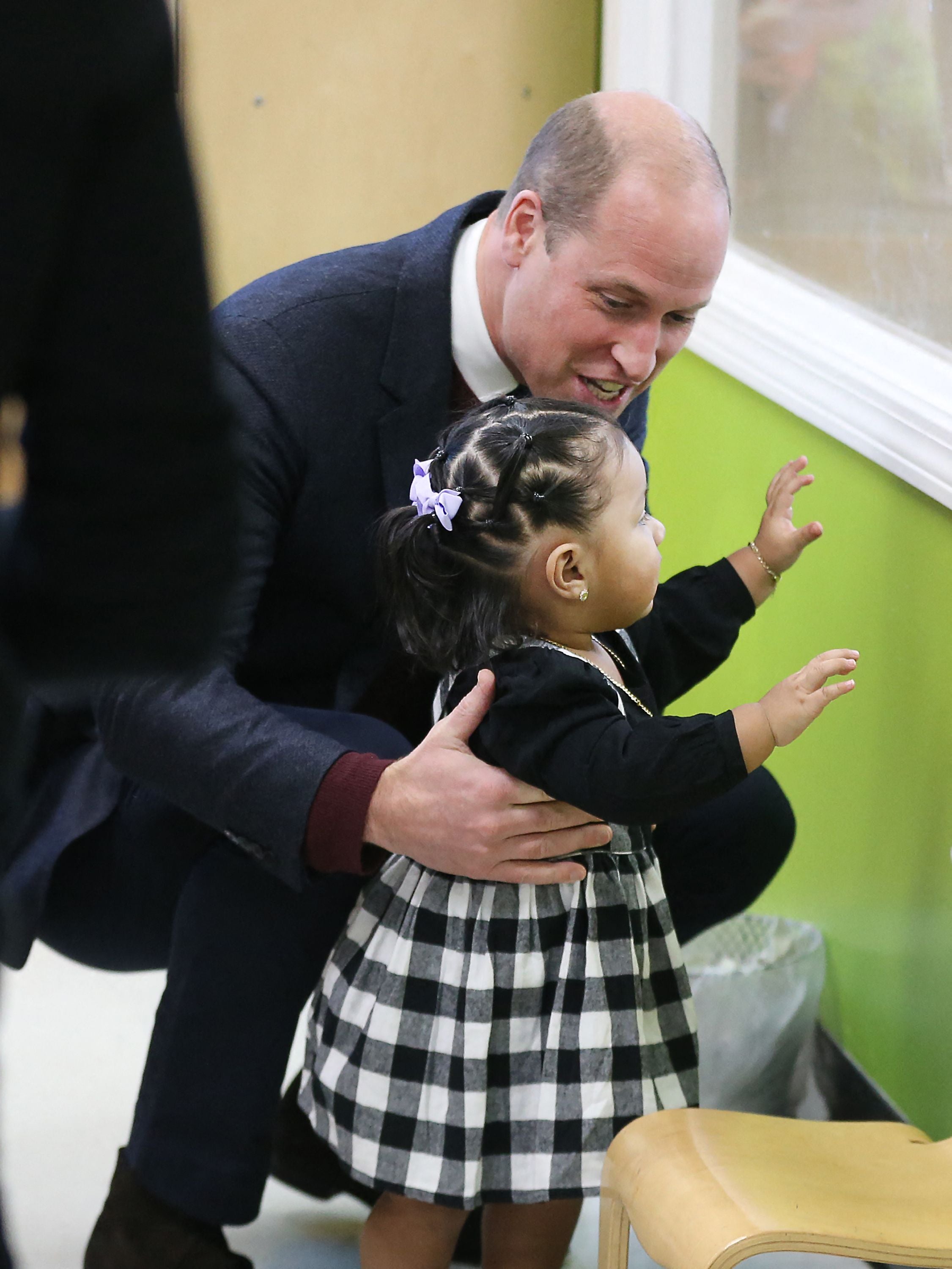 Britain's Prince William, Prince of Wales, engages with 16-month-old Sofia during a visit to Roca Inc, an organization working to reduce urban violence through community engagement efforts, in Chelsea, Massachusetts, on December 1, 2022