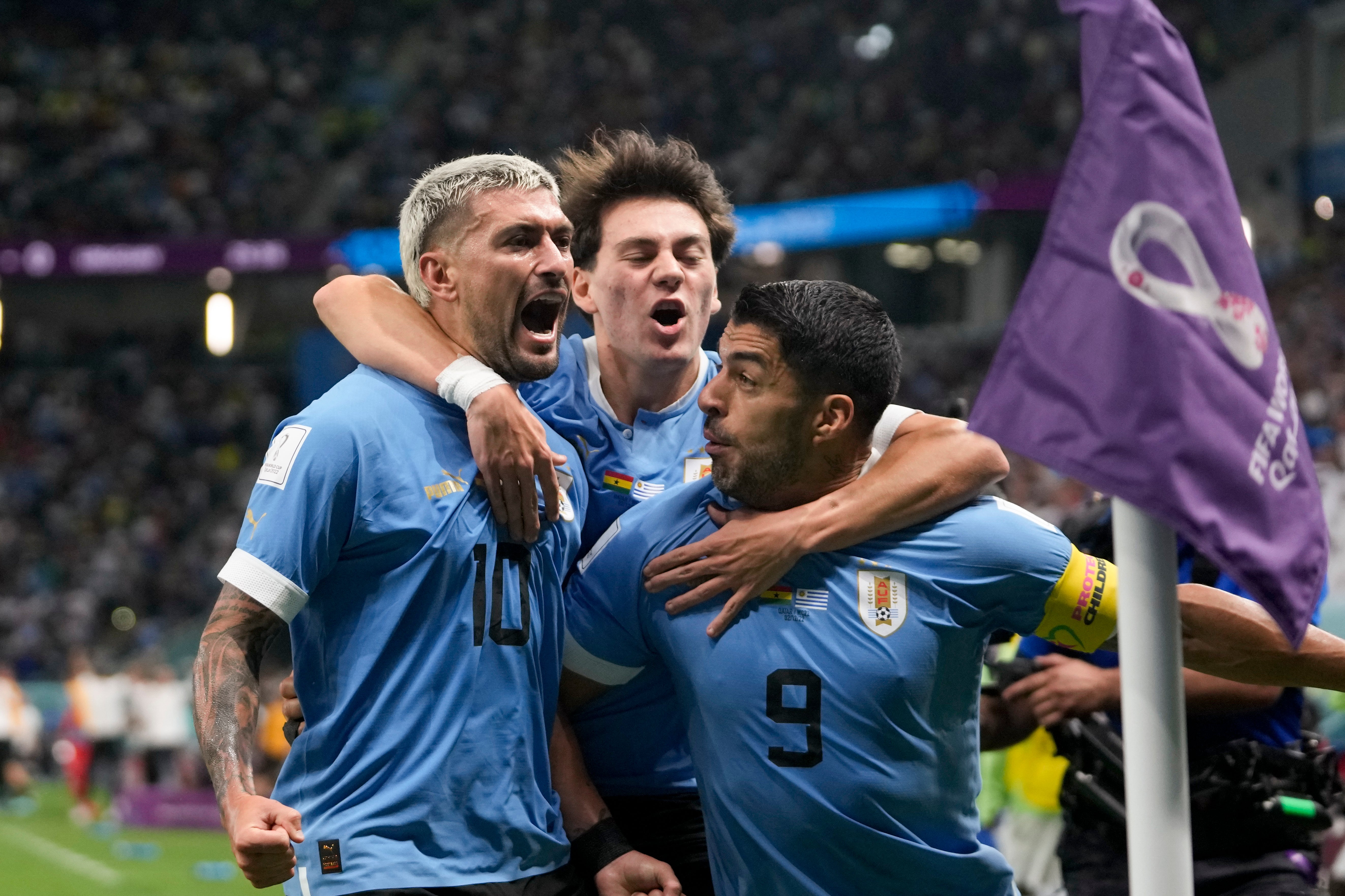 Uruguay's Giorgian de Arrascaeta, left, celebrates with teammate Luis Suarez scoring the opening goal