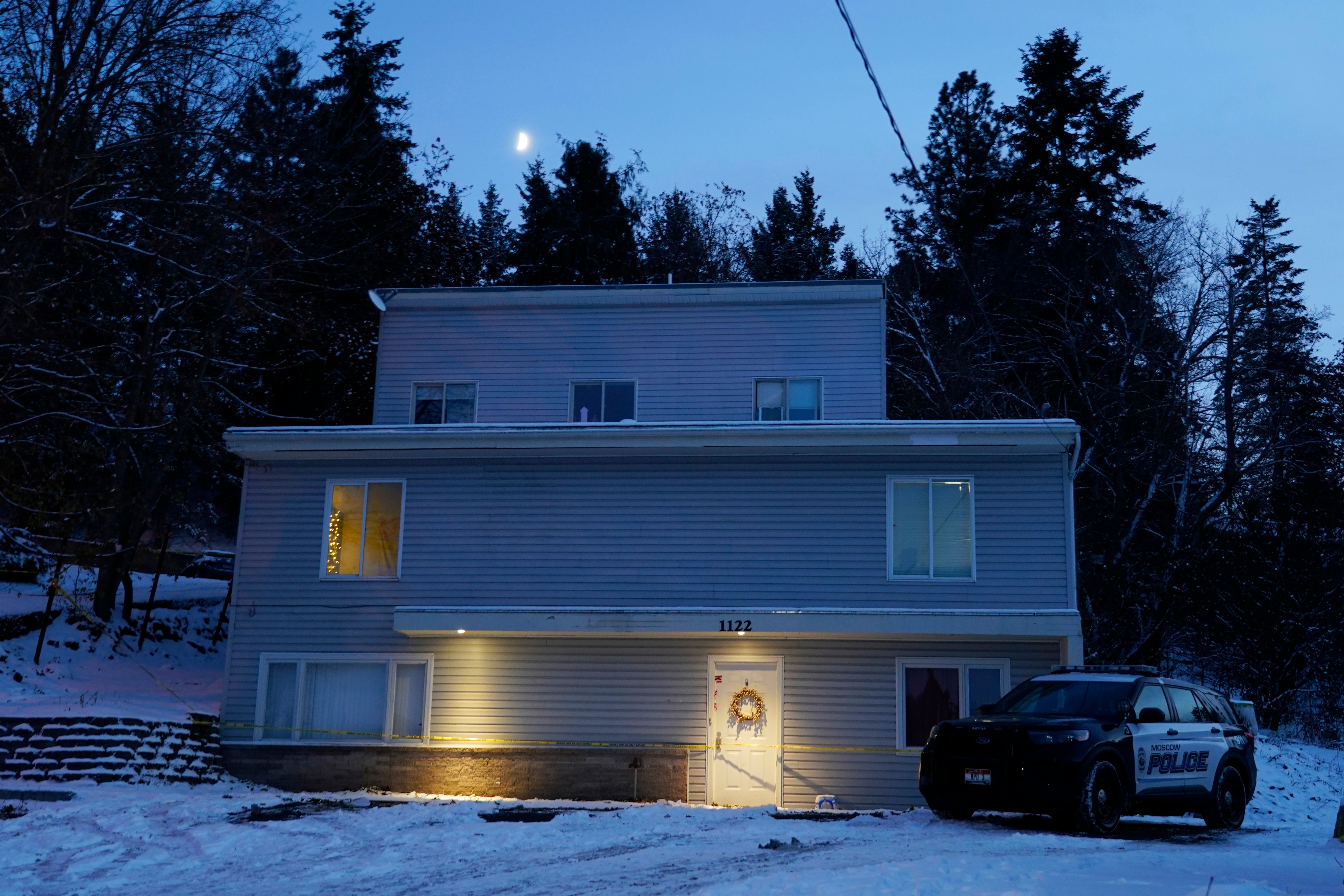 The moon rises on Nov. 29, 2022, as a Moscow police officer stands guard in his vehicle at the home where four University of Idaho students were murdered