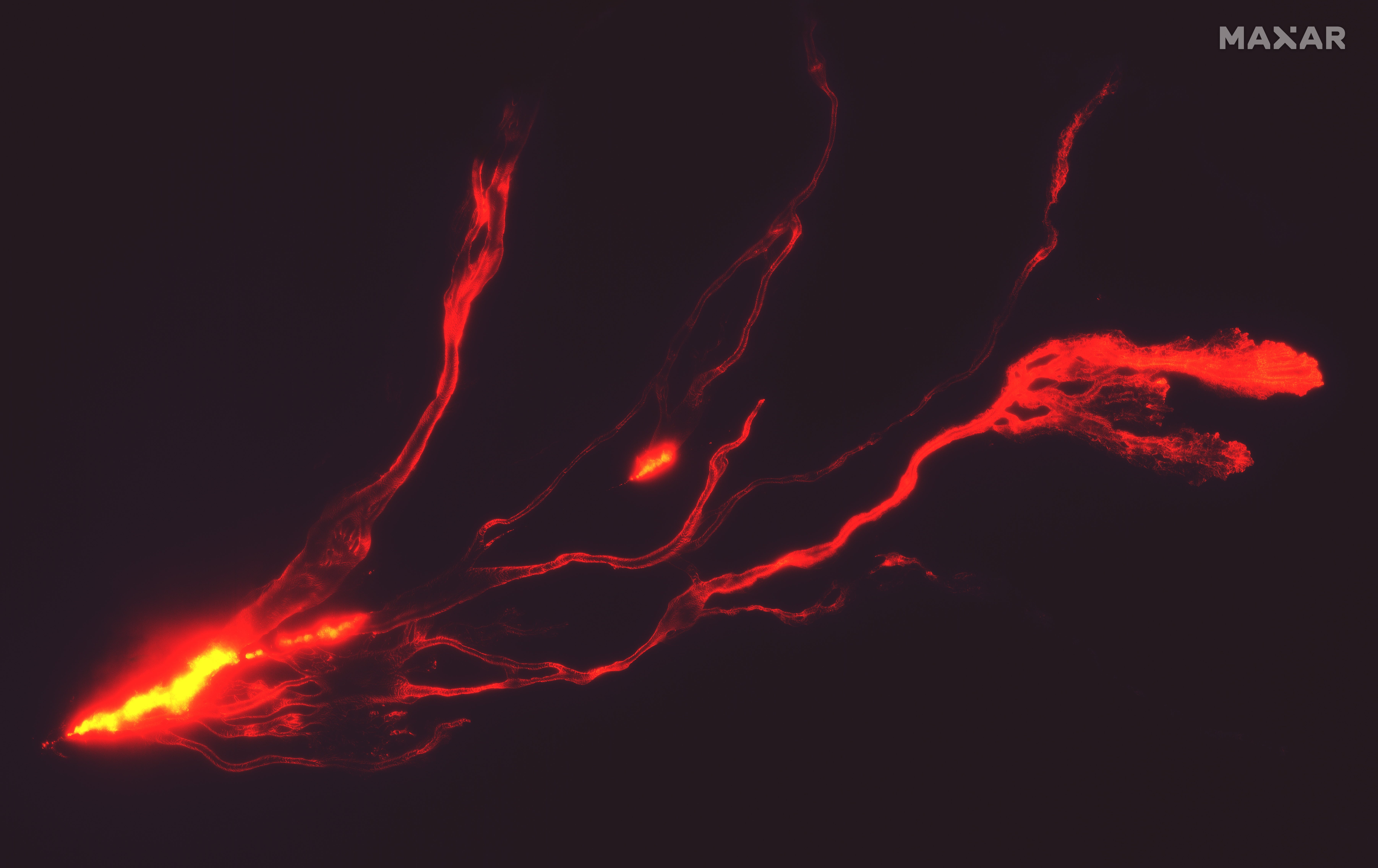 A handout satellite image made available by Maxar Technologies shows a night time overview of lava flows from Mauna Loa