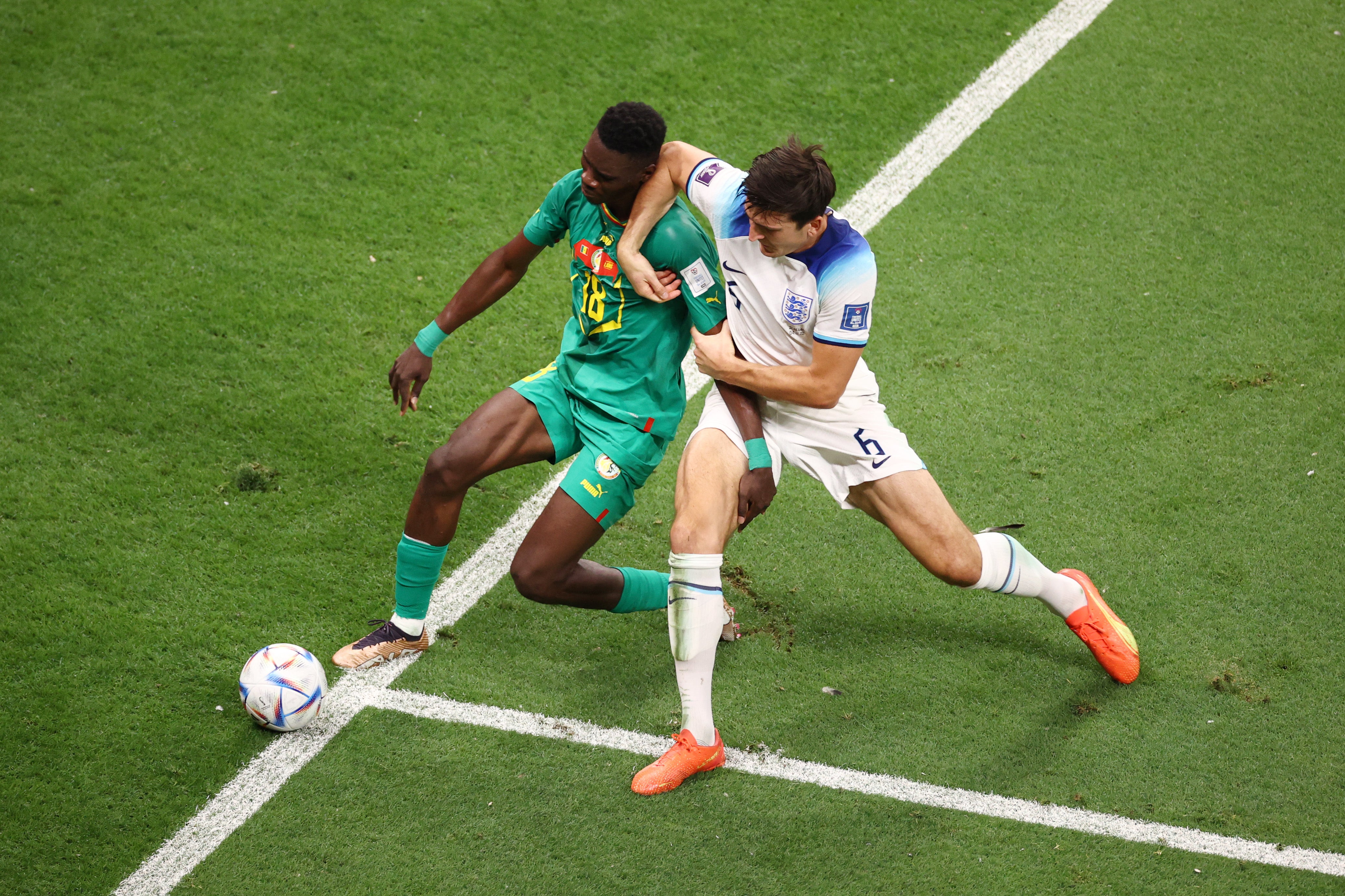 John Stones of England is challenged by Ismaila Sarr of Senegal