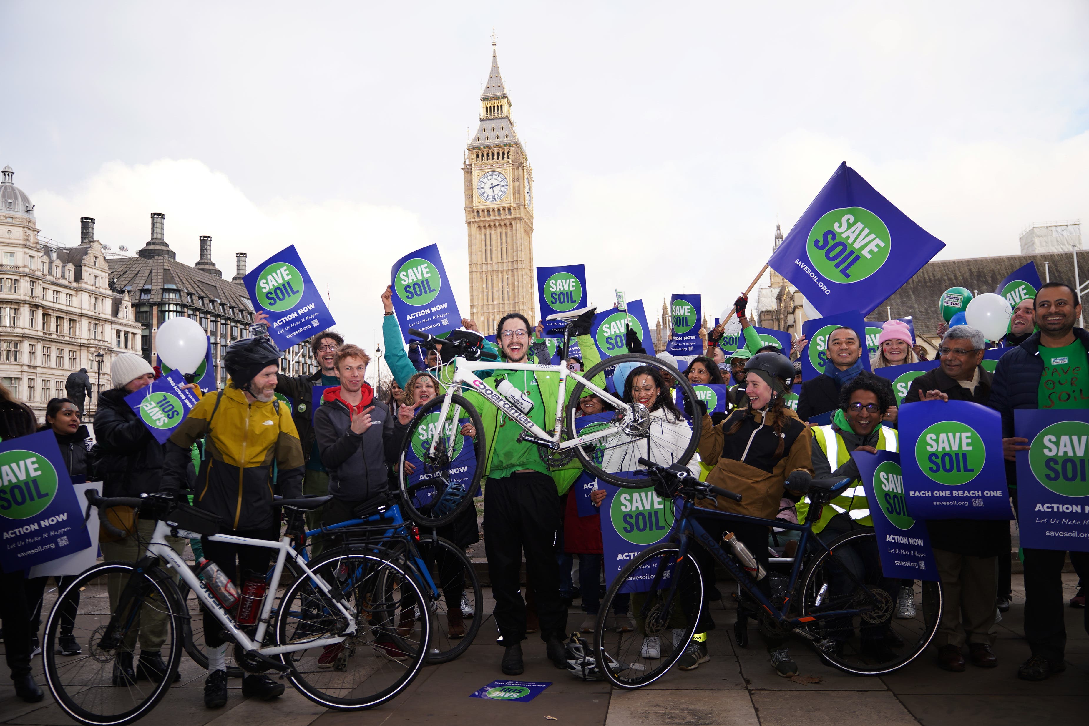 Oscar Smith (centre, holding bike), 17, was welcomed by a group of Save Soil supporters in Parliament Square