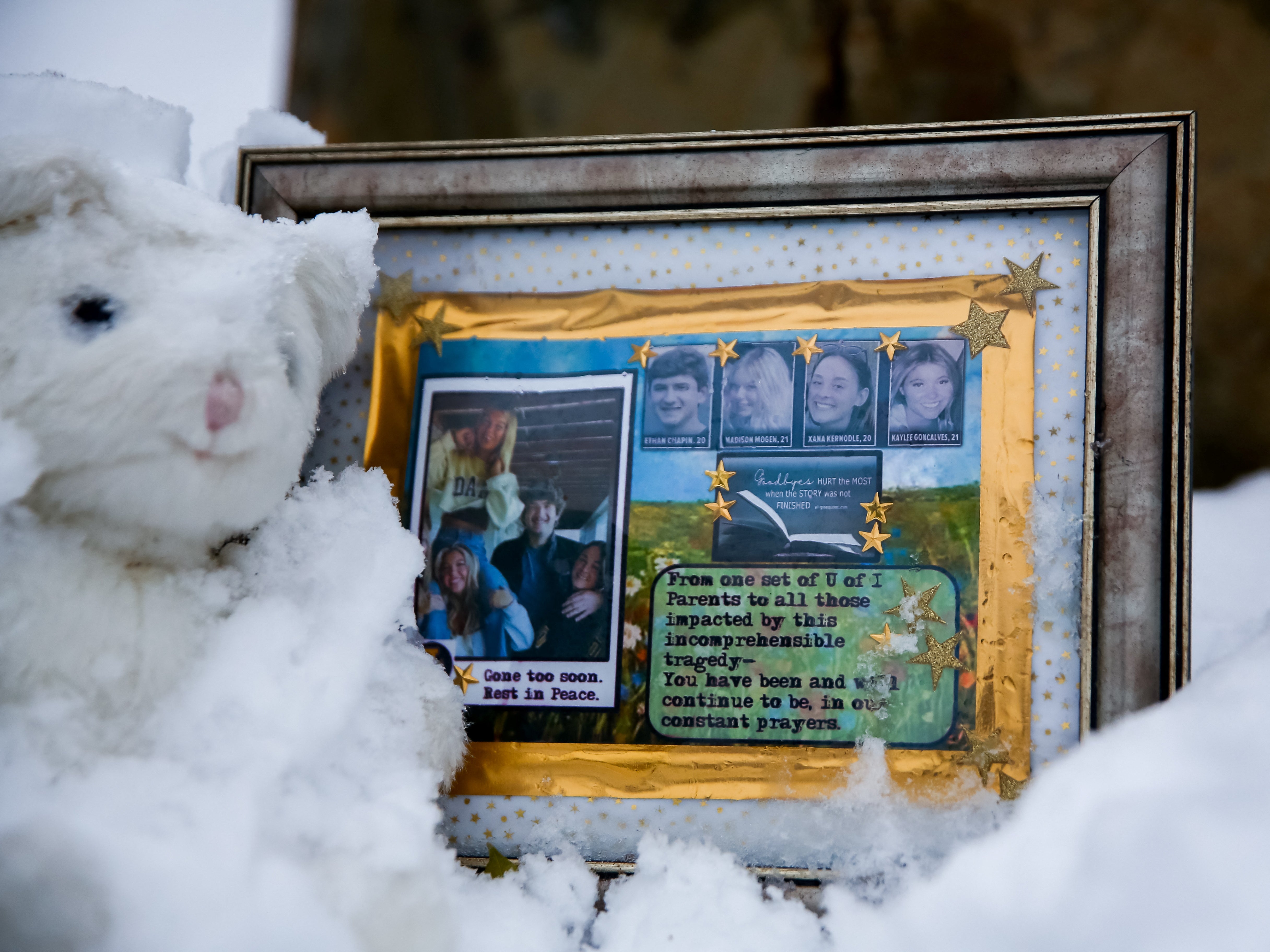 A small frame remembering the victims sits in the snow outside of the residence where the four students were killed