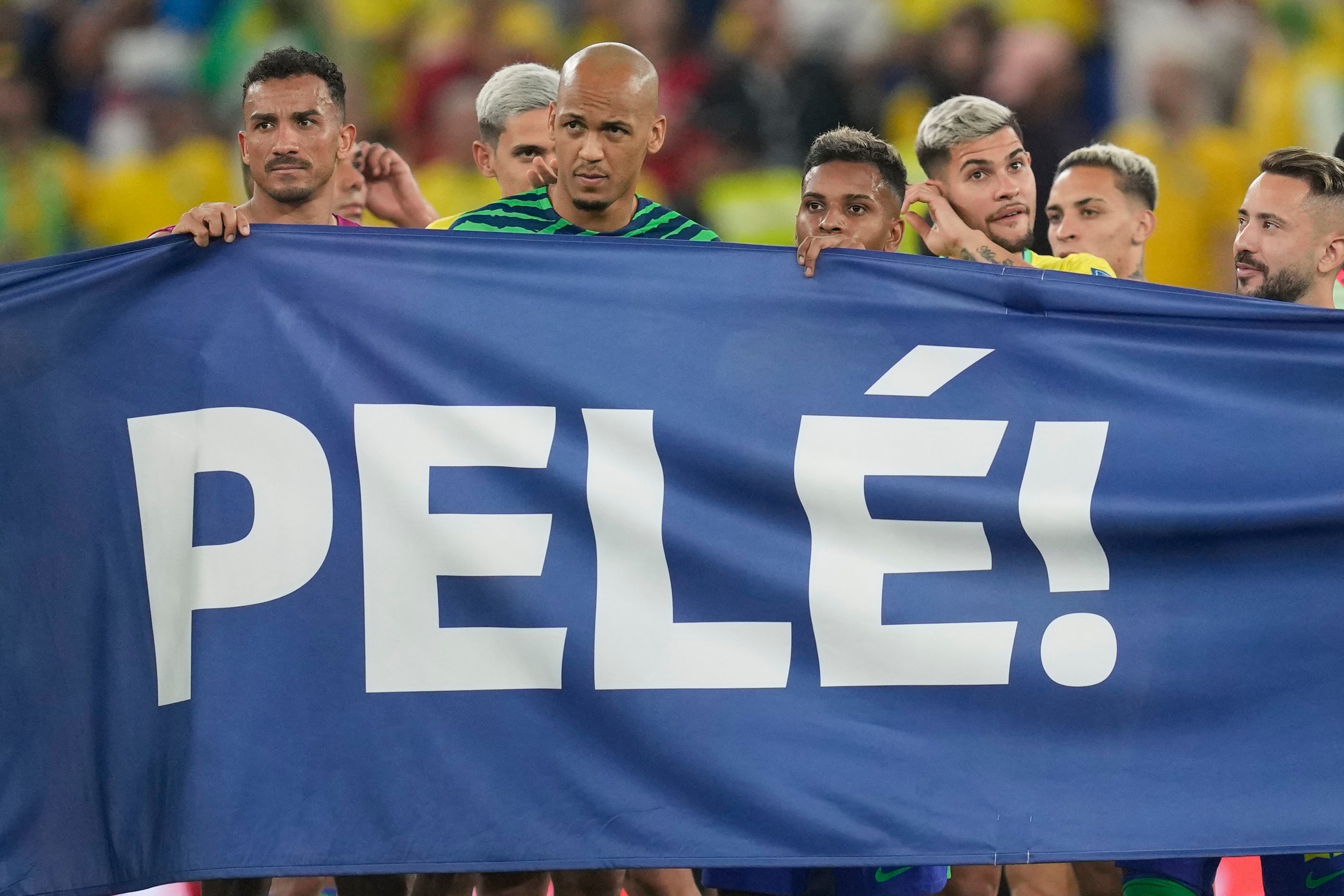 Brazilian players hold a banner in honour of Pele