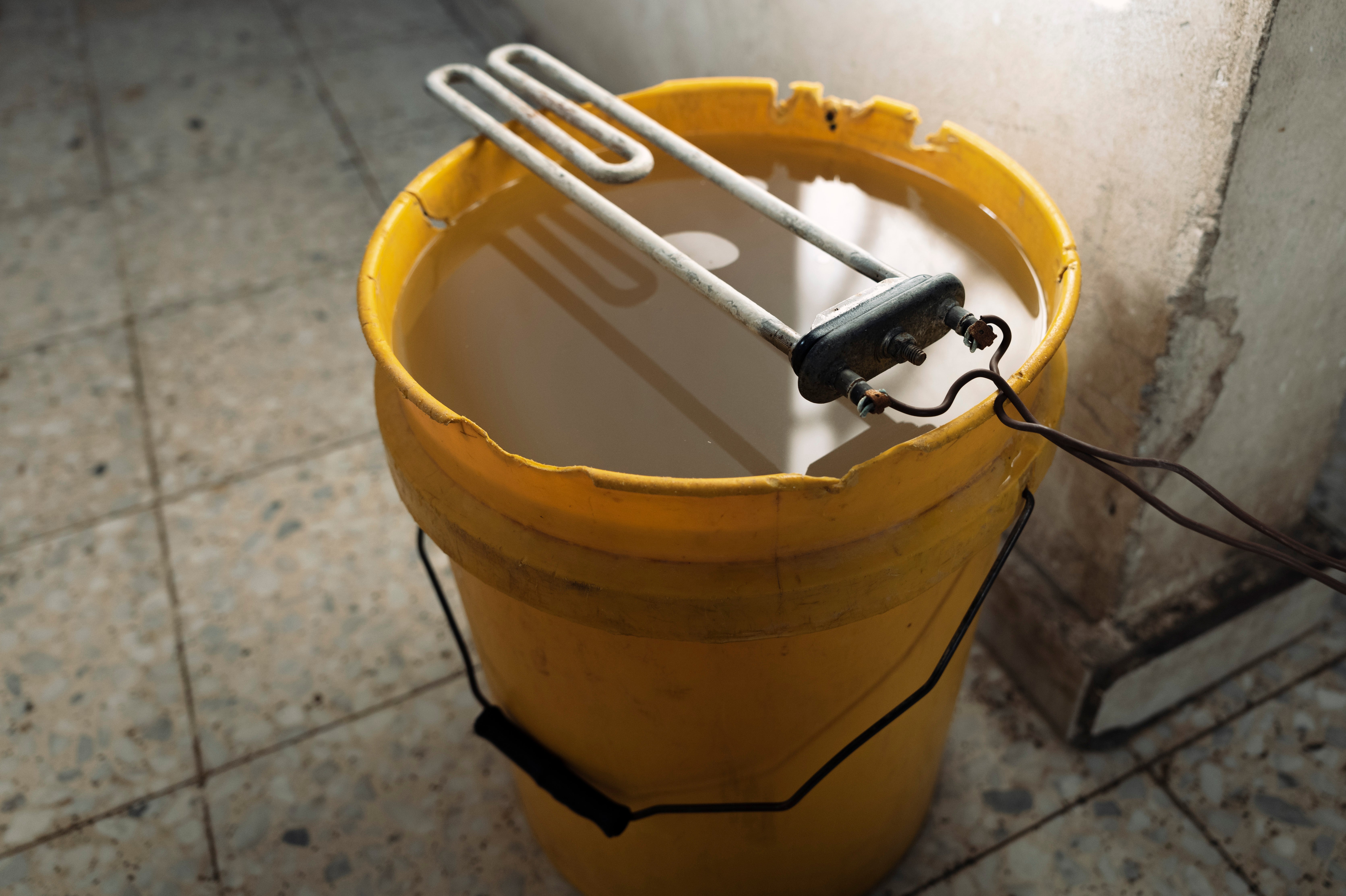 The heating element resting on a bucket of water