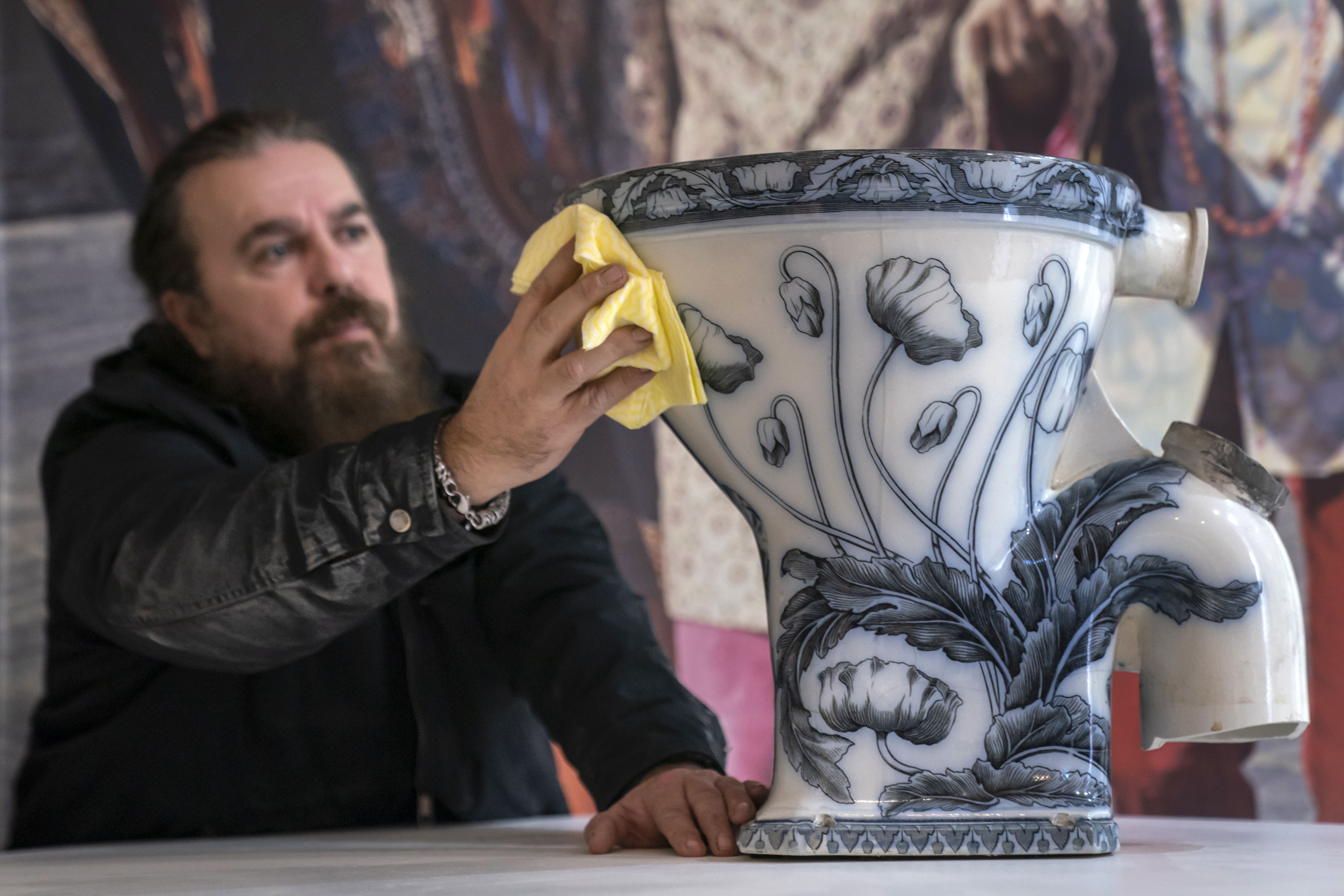 Roag Best gives a final polish to John Lennon’s toilet from his Tittenhurst Estate in Berkshire, where he lived with Yoko Ono in 1971, ahead of the item going on display at the Liverpool Beatles Museum (Danny Lawson/PA)