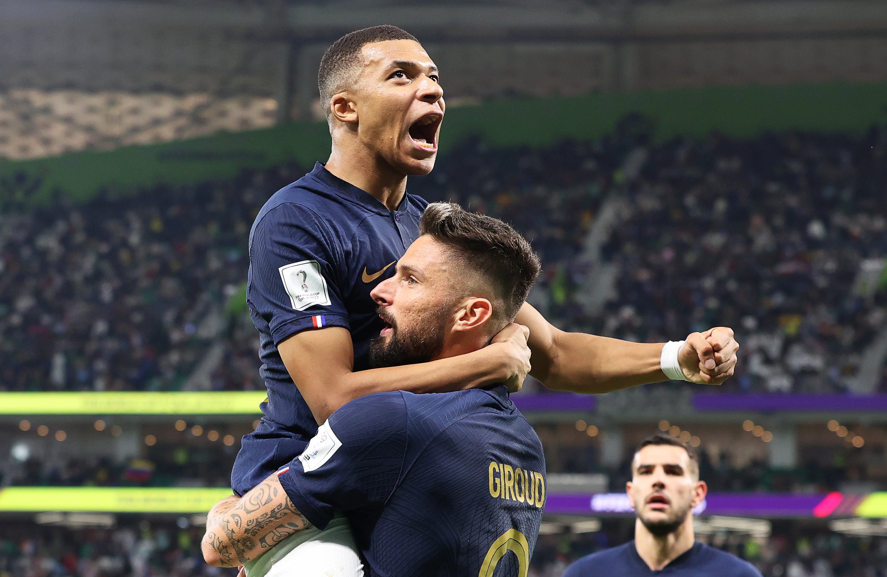 Kylian Mbappe celebrates a World Cup goal against Poland with France teammate Olivier Giroud