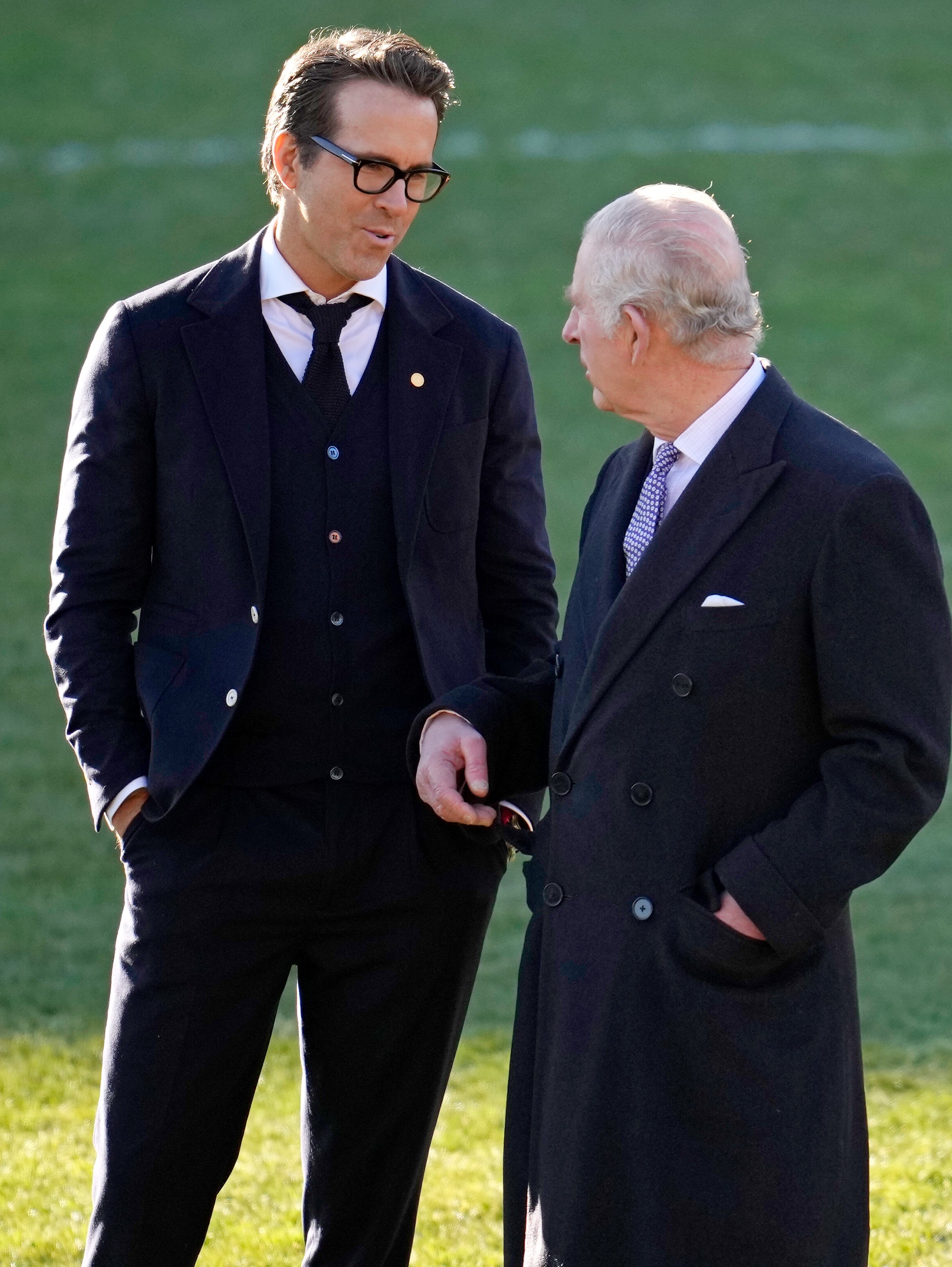 King Charles III talks to Co-Owner Wrexham AFC Ryan Reynolds (L) during their visit to Wrexham AFC